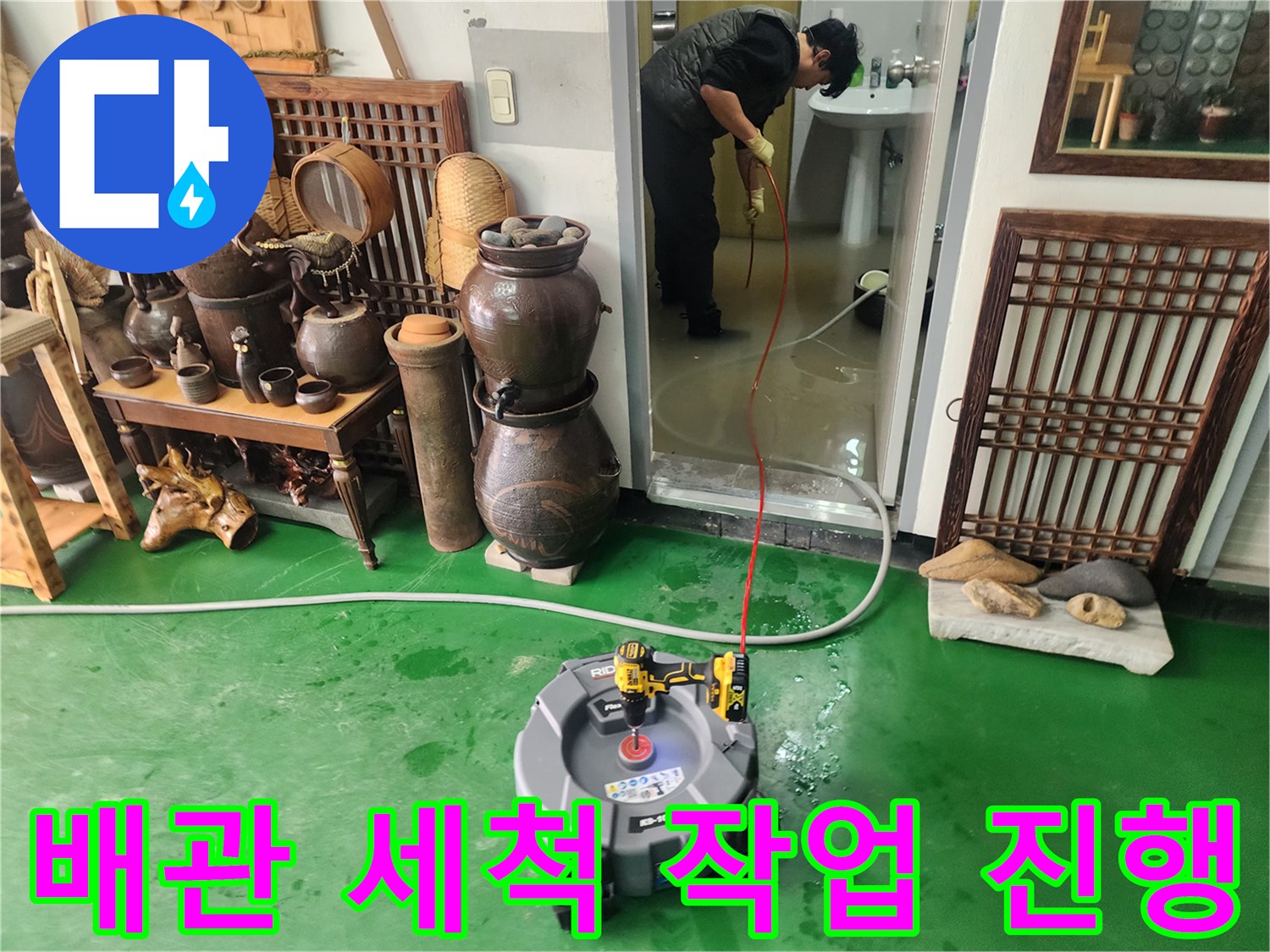 초록색 바닥 위로 연결된 고압 호스와 세척 장비