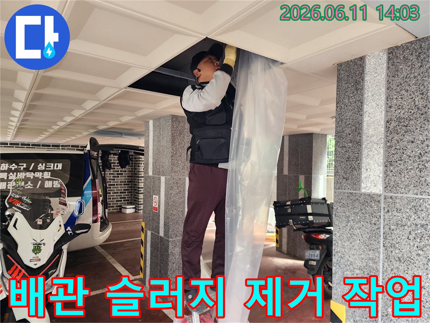 천장 타공 부위에서 배관 내부의 막힘을 해결하기 위해 노력하는 모습입니다.