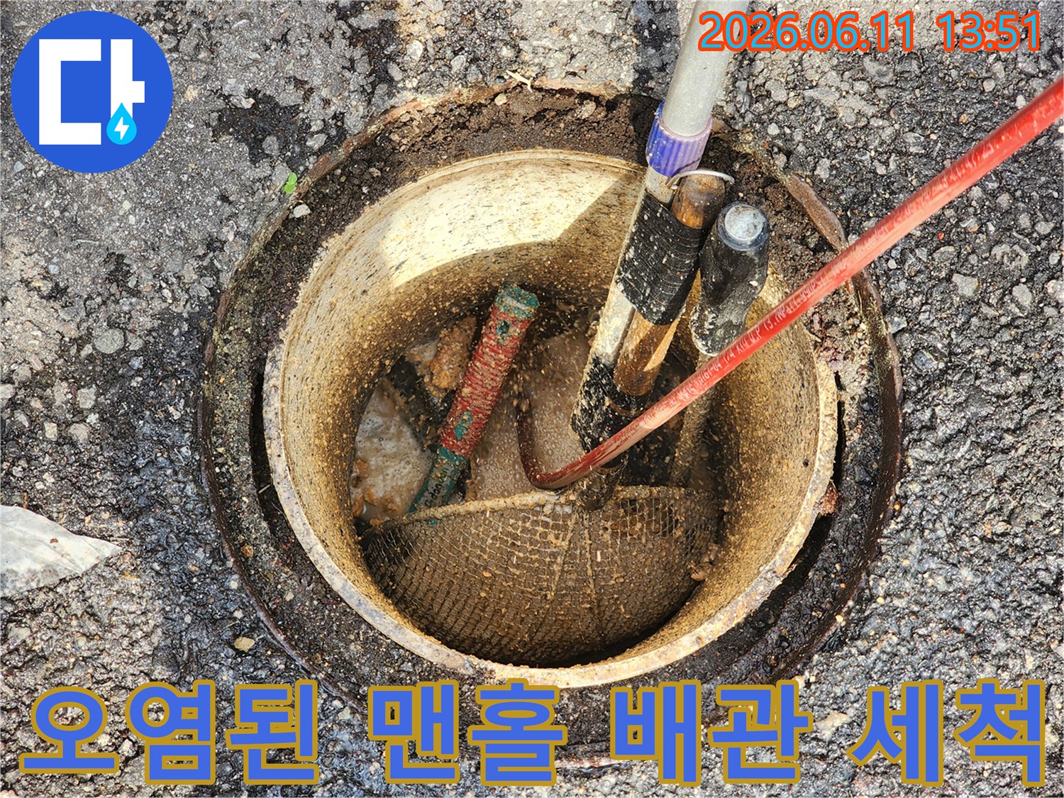 흙과 오물로 오염된 맨홀 내부의 배관 세척 장비 모습