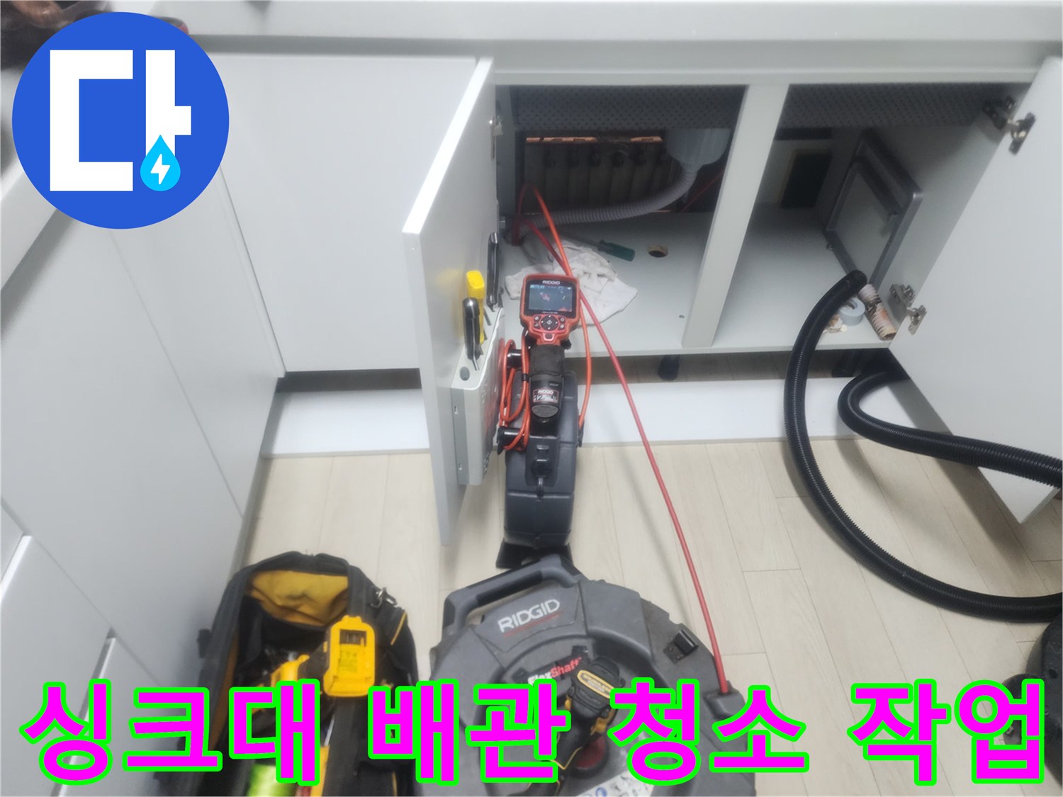 싱크대 아래쪽 배관에 스케일링 케이블을 연결하여 진행하는 공사 현장