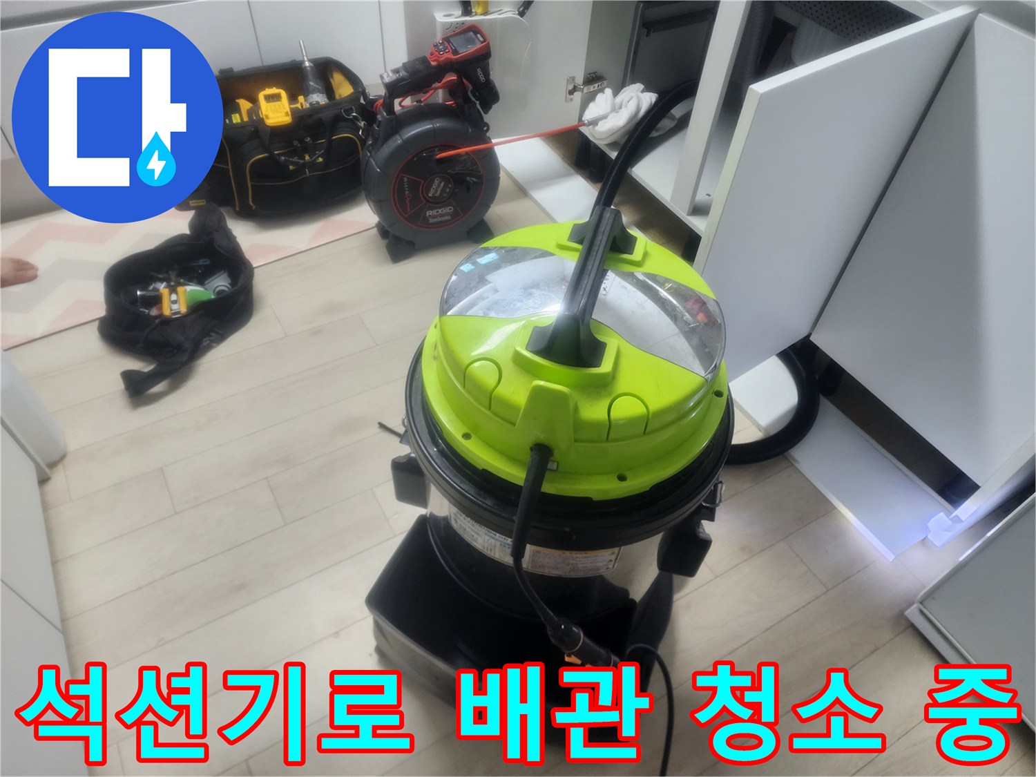 싱크대 하부장 배관 세척을 위해 배치된 석션 장비와 도구들