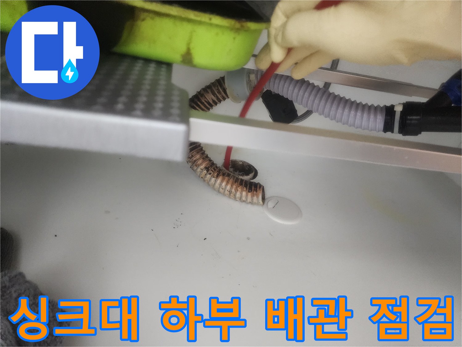 싱크대-하부장-내부의-주름관-배수관과-점검용-장비-모습