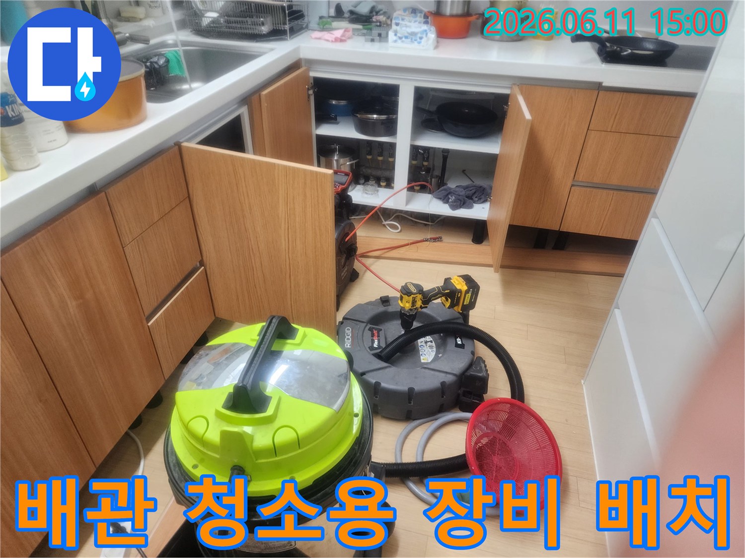 싱크대 하부 배관 작업 공간에 준비된 흡입기와 스케일링 도구