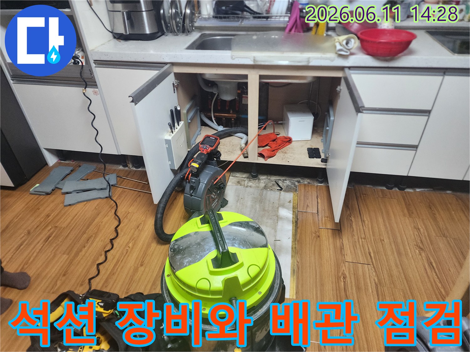 싱크대 하부장 아래 배치된 석션기와 배수관 주변의 작업 환경입니다.