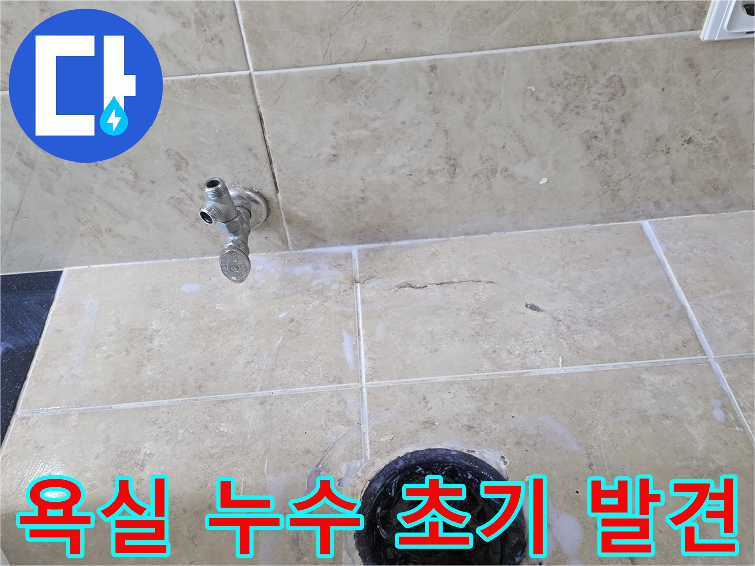 욕실 바닥의 수도꼭지와 배수구 주변에 나타난-미세한 물때 자국과 타일의 상태를 보여주는 현장 사진입니다