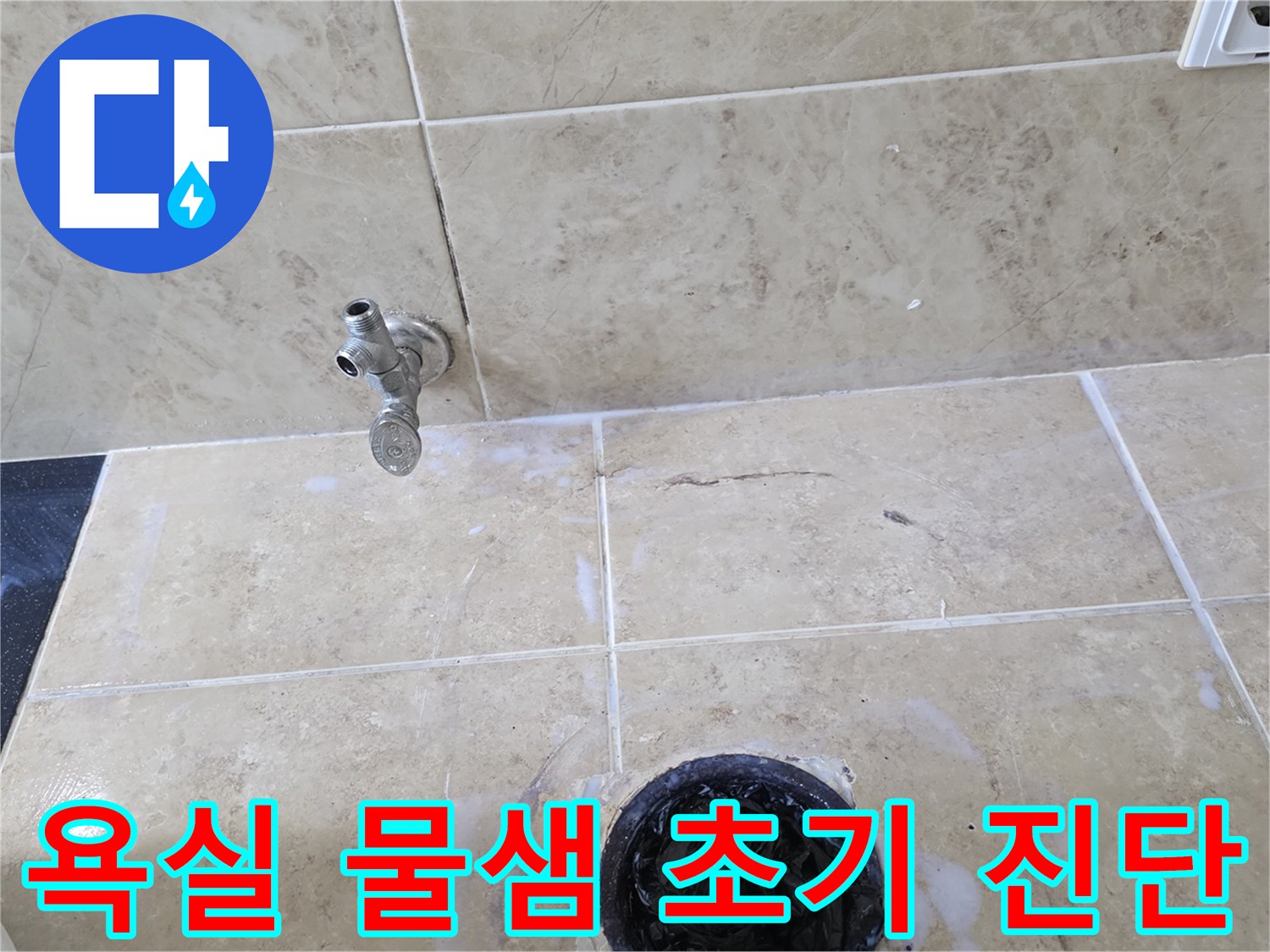 욕실 바닥의 수도꼭지와 배수구 주변에 나타난-하얀 물때 자국과 타일 균열을 보여주는 현장 사진입니다