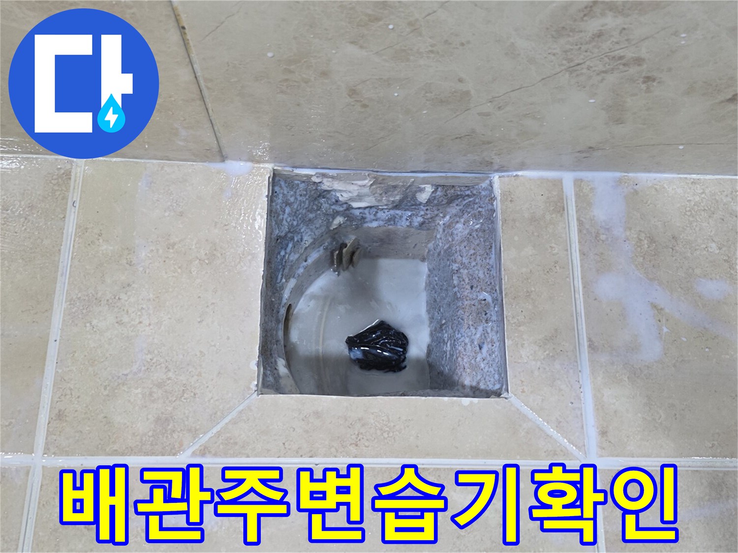 이 이미지는-안양 비산동 욕실 누수 현장에서-타일을 제거한 후-배관 주변의 습기 상태를-확인하는 과정을 보여줍니다