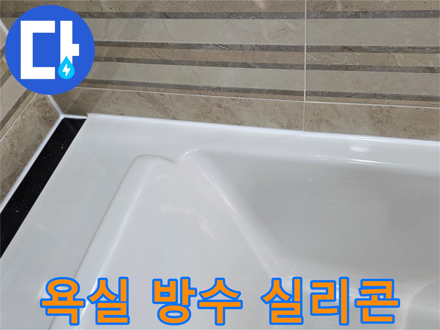 이 이미지는 욕실 욕조와-벽 타일 사이의-새로운 방수 실리콘 마감을-근접 촬영한 것으로-누수 예방을 위한-정교한 작업 결과를 보여줍니다.