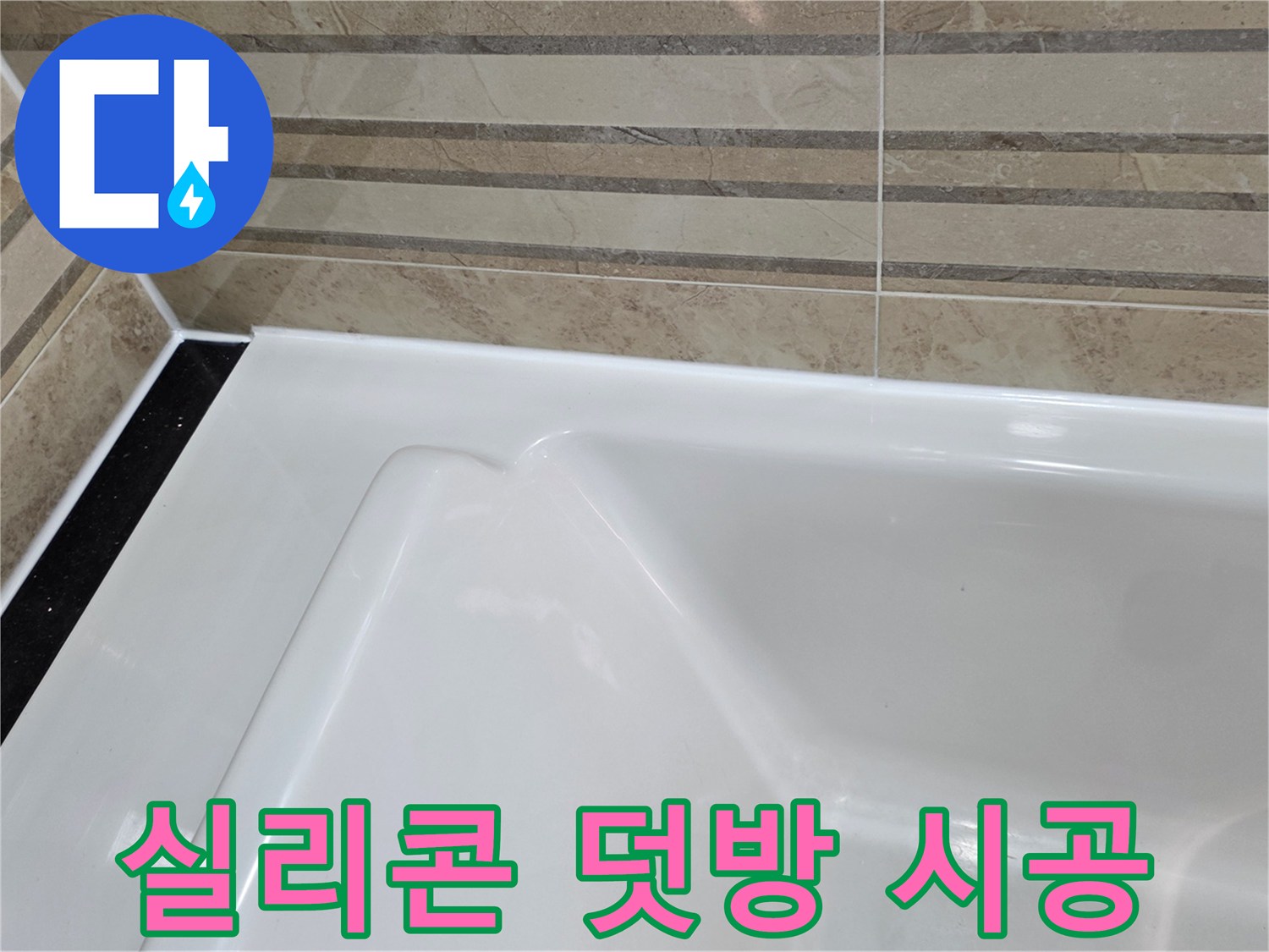 이 이미지는 욕실의 욕조와-벽 타일 경계면에-새롭게 덧방 시공된-방수 실리콘 마감을 보여주며-이는 누수 방지를 위한-효과적인 보강 작업의-결과입니다.