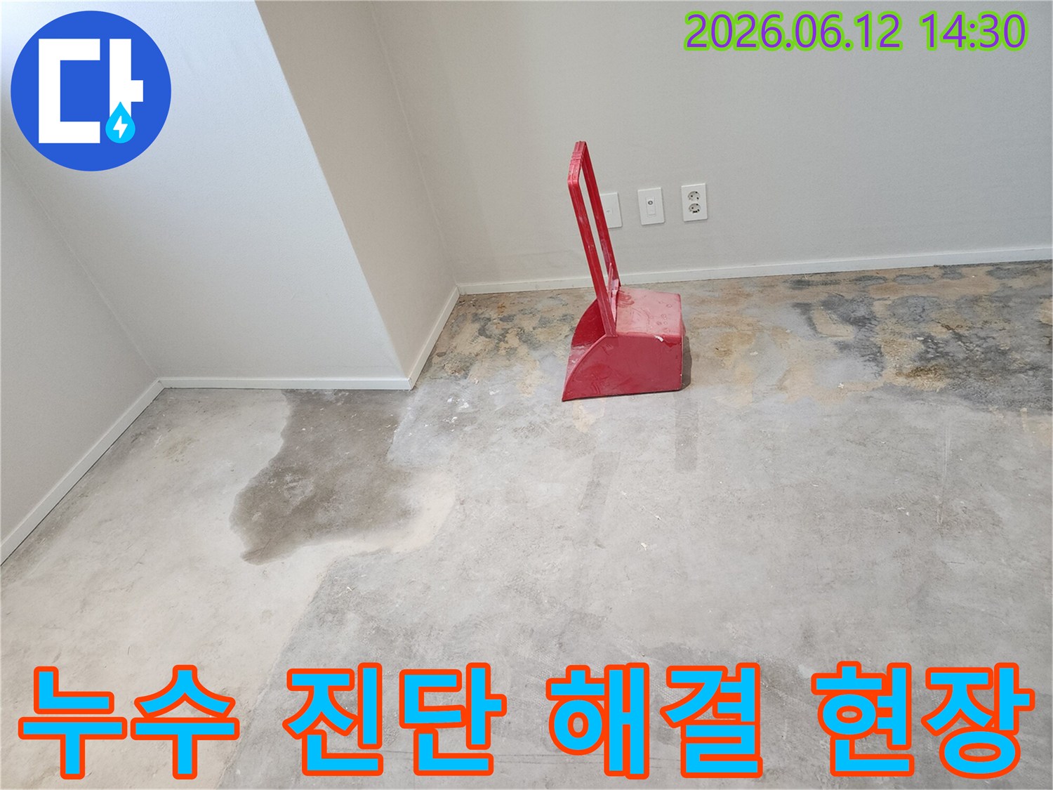누수-현장에서-콘크리트-바닥이-젖어있고-빨간색-청소-도구가-놓여있는-모습