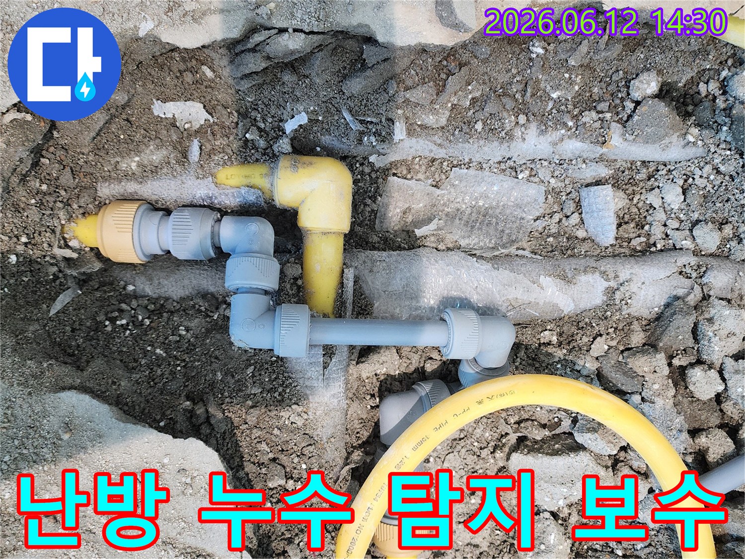 땅속에 매설된 노란색 가스-배관과 회색 난방-배관이 드러난 모습으로-누수 해결을 위한 난방-배관 보수 공사 현장입니다