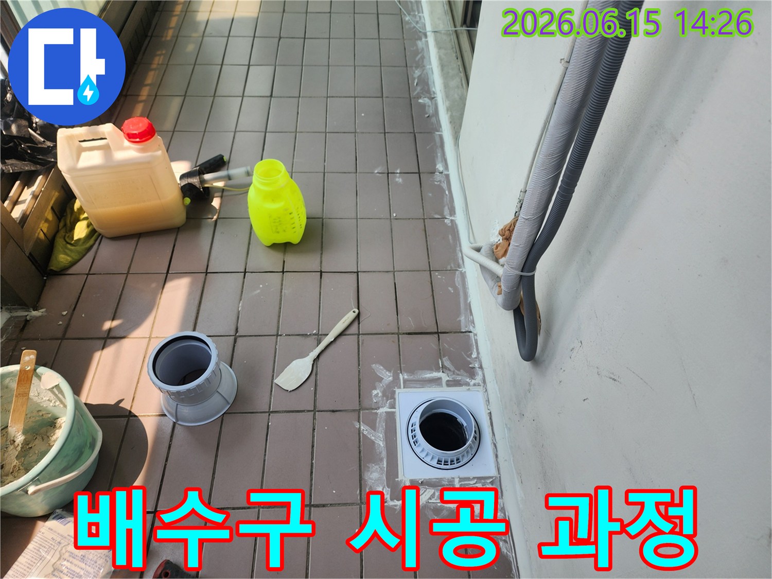 베란다 바닥에-새로운 배수구를 설치하고-주변 타일 및 백시멘트 마감을-진행하는-누수 공사 현장입니다.