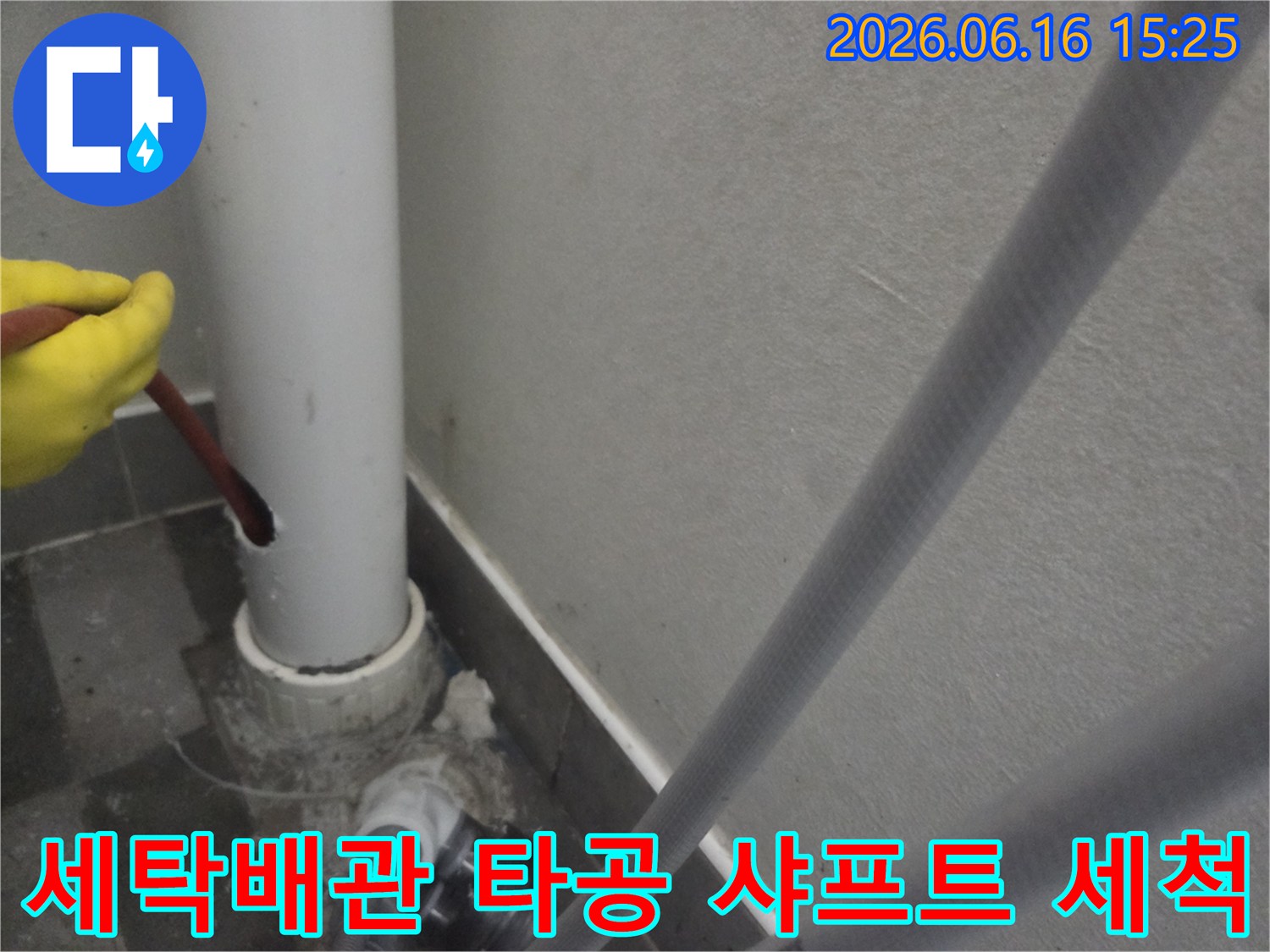세탁실 배관에-타공 작업을 진행하고-샤프트를 이용해-내부를 세척하는 모습입니다