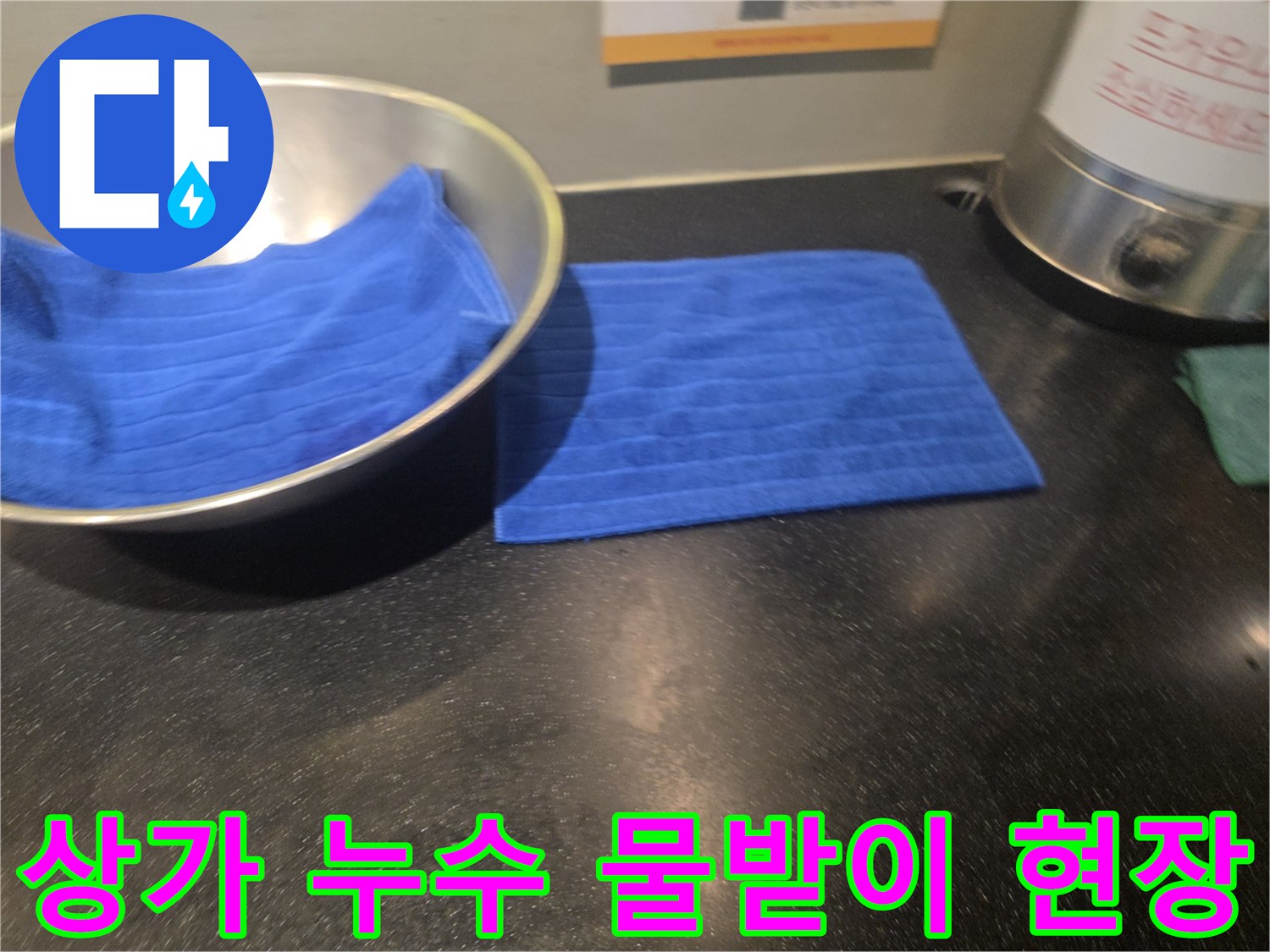 아랫집 상가 천장에서 물이 새어 나와-물받이와 수건으로 임시 조치된-누수 피해 현장의 모습