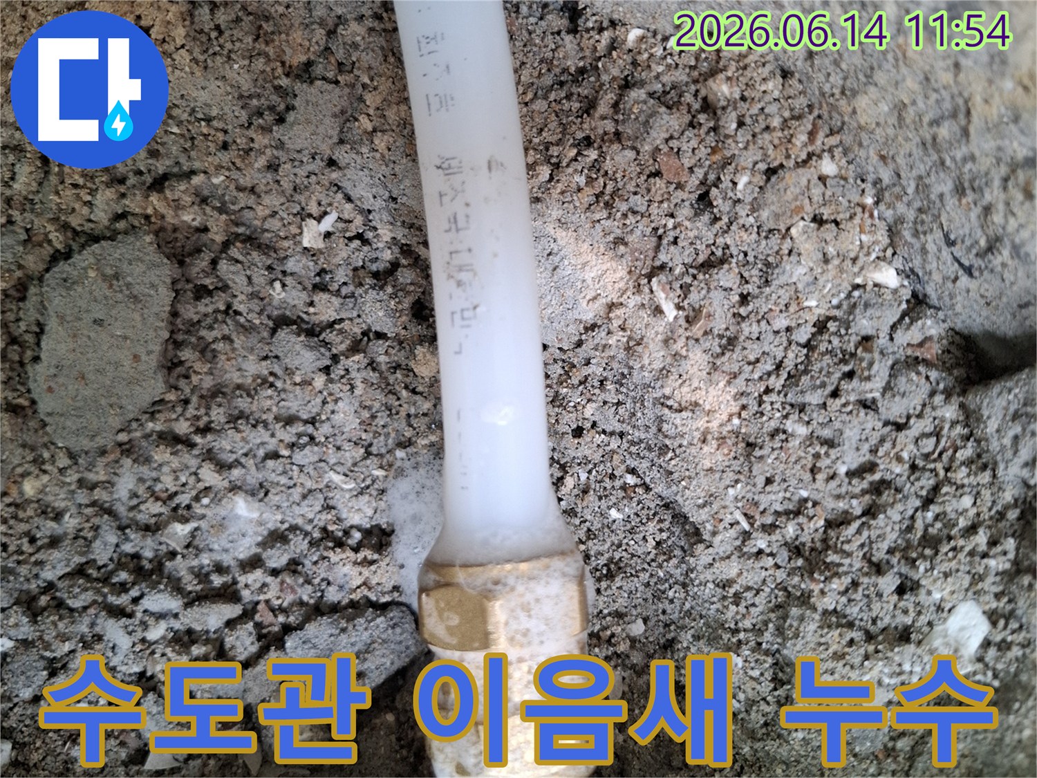 매설된-수도관의-연결부에서-하얀-침전물과-함께-누수가-발생하고-있는-모습을-담은-사진