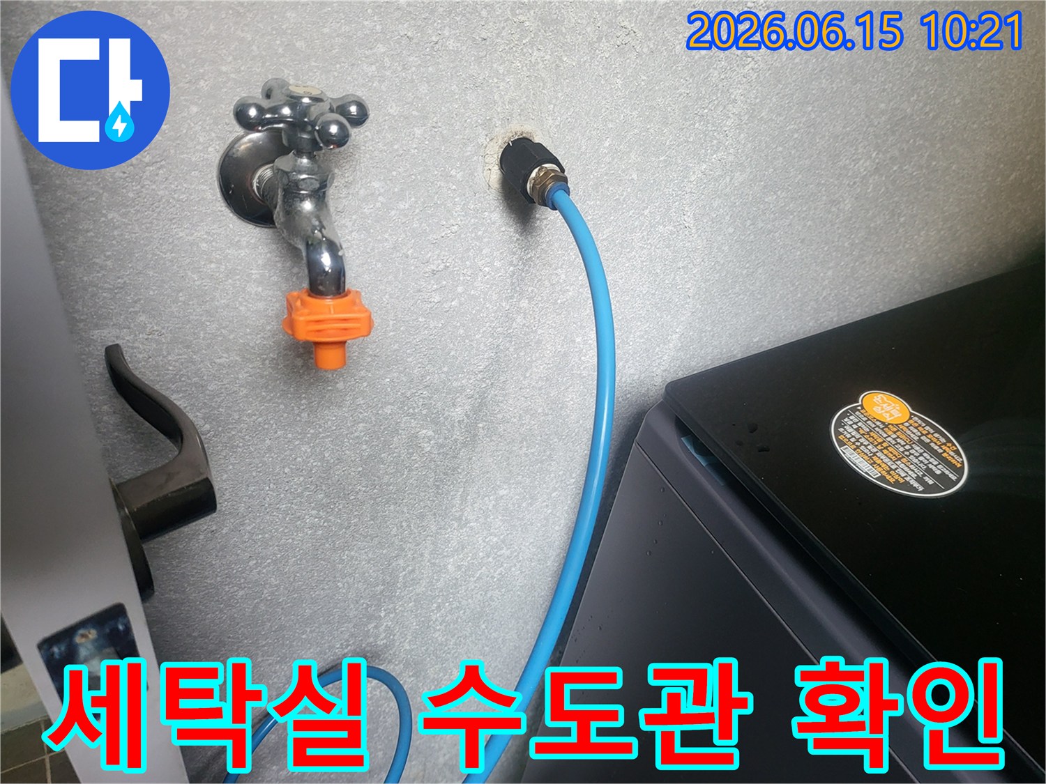 세탁실 벽면의 수도꼭지와-급수 호스 연결 부위를-전문가가 면밀히 확인하는 과정입니다.