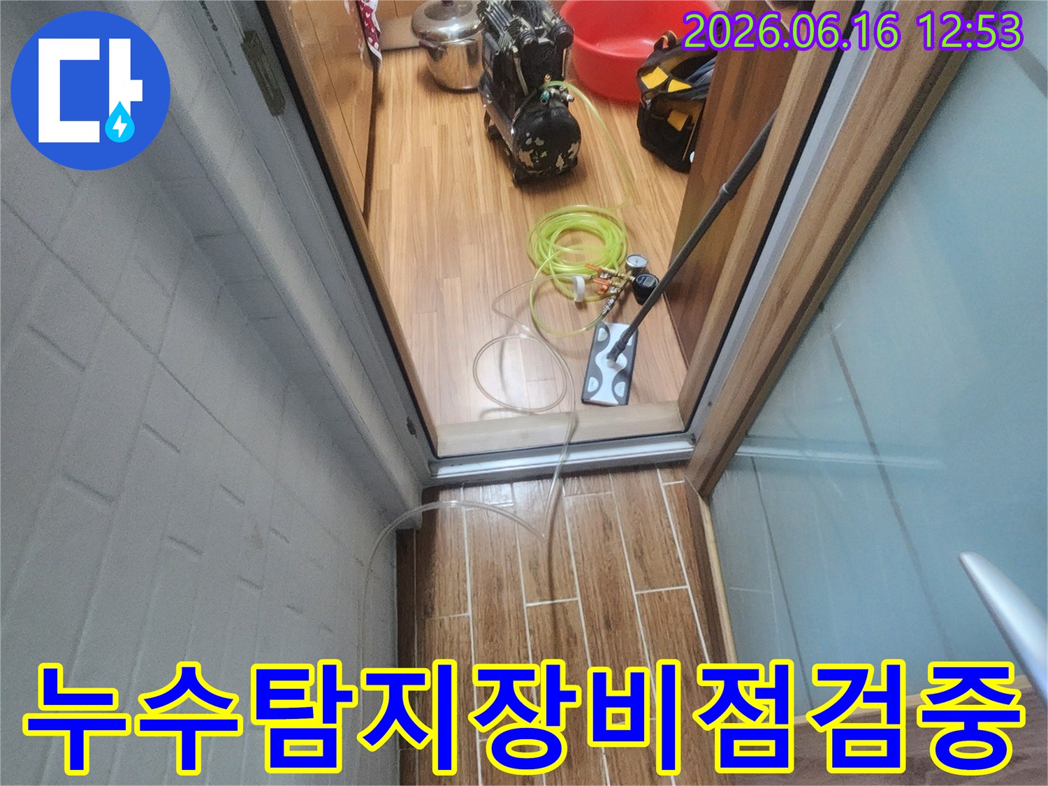 누수 엔지니어가 아파트 내부에서 누수-탐지 장비를 점검하며 작업을 준비하는 모습입니다.