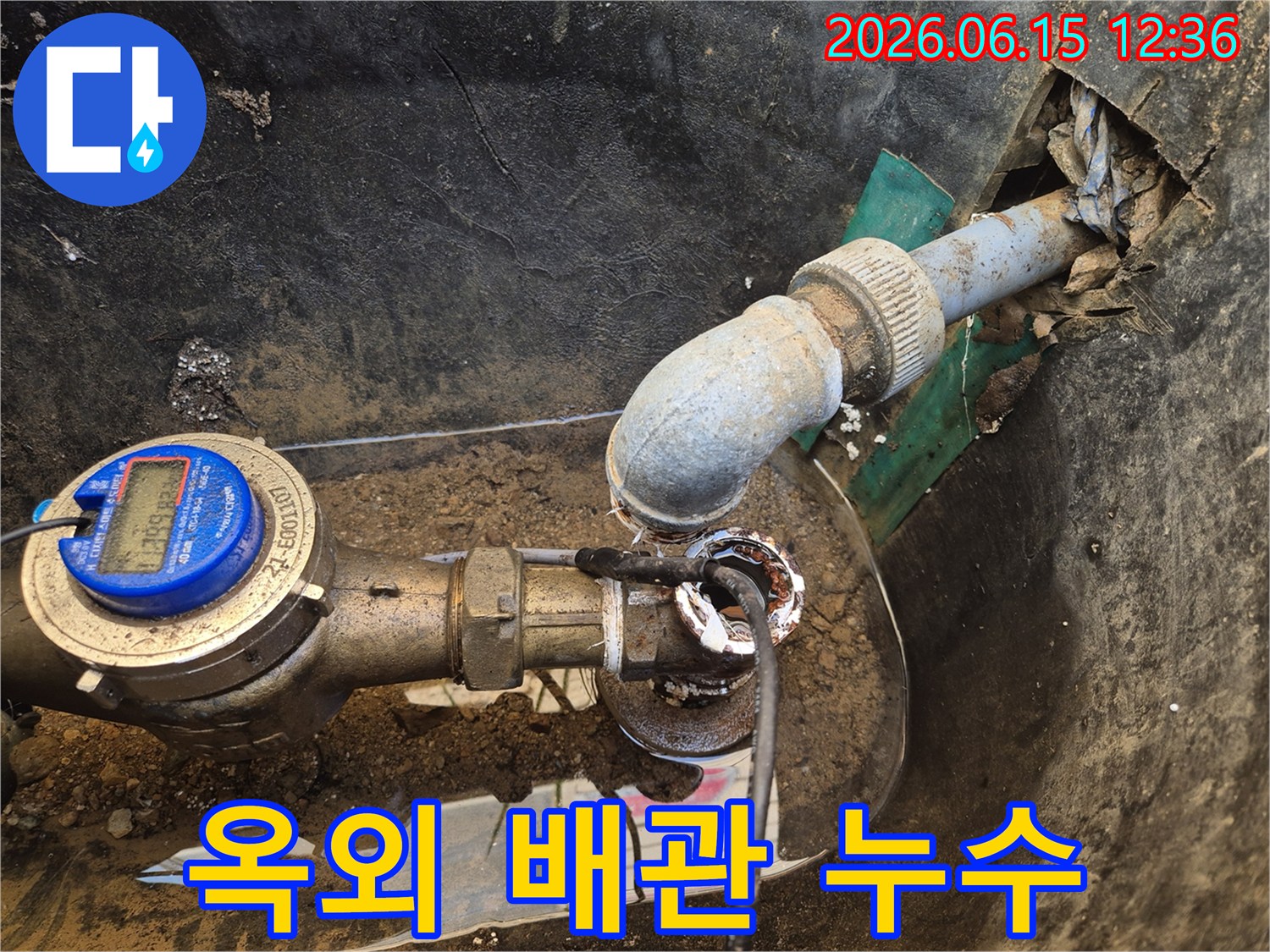 이 이미지는-옥외에 매설된-배관의-연결 부위에서-물이 새는-모습을-보여줍니다-오랜 사용으로-인한-부식과-손상이-원인으로-보입니다