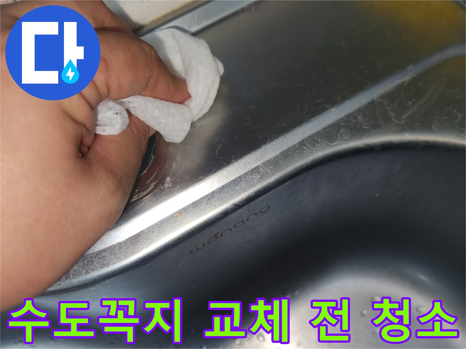싱크대 상판의 수도꼭지 구멍 주변을- 젖은 천으로 꼼꼼히 닦아내는 손의 모습입니다