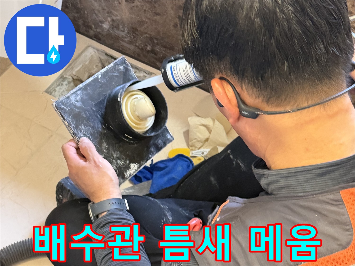 배수구 주변의 빈 공간을 방수재로 채워 넣는 정밀 시공 장면입니다.
