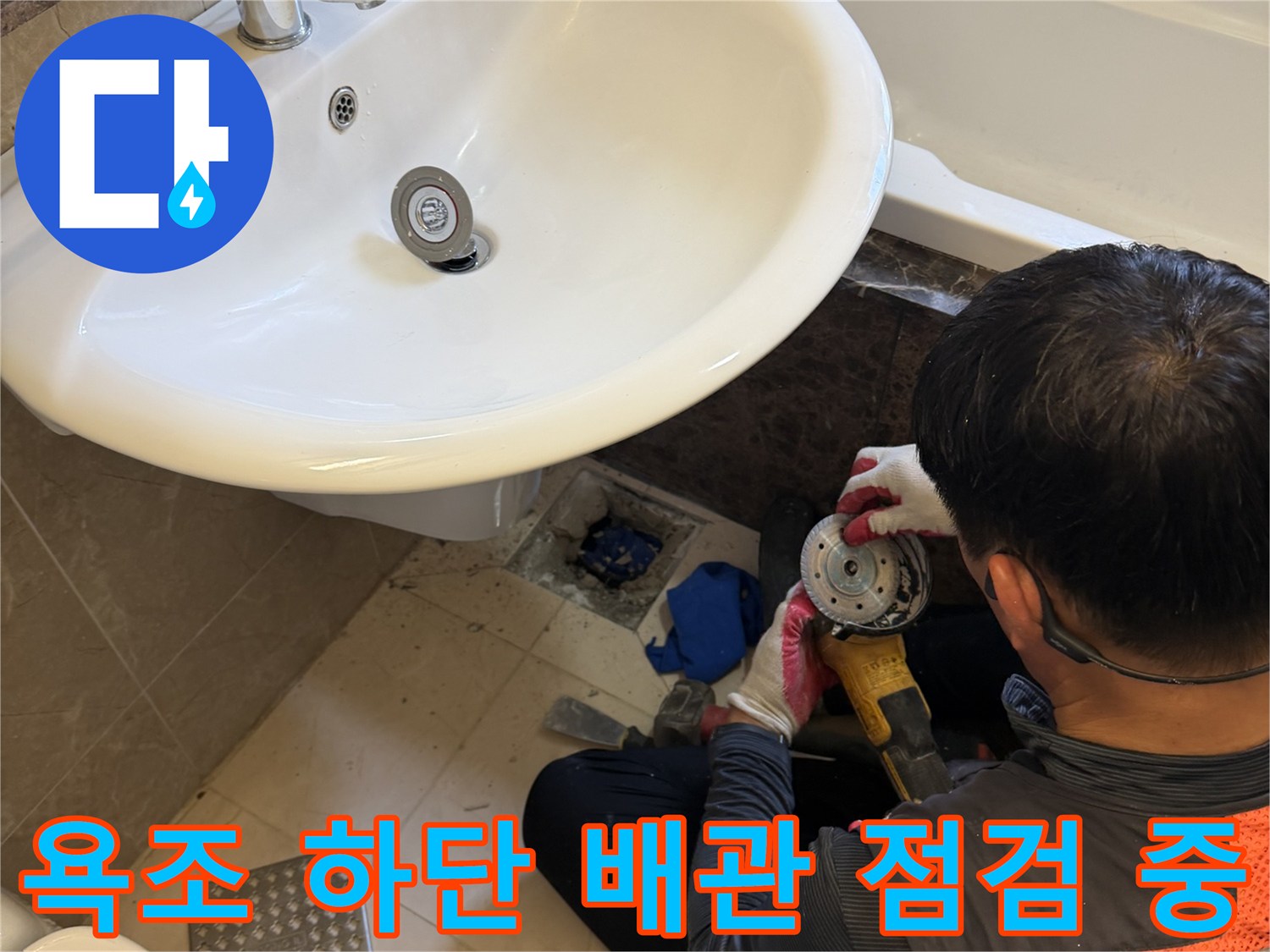 욕조 밑 배수구 주변의 누수 지점을 면밀히 검토하는 장면입니다.