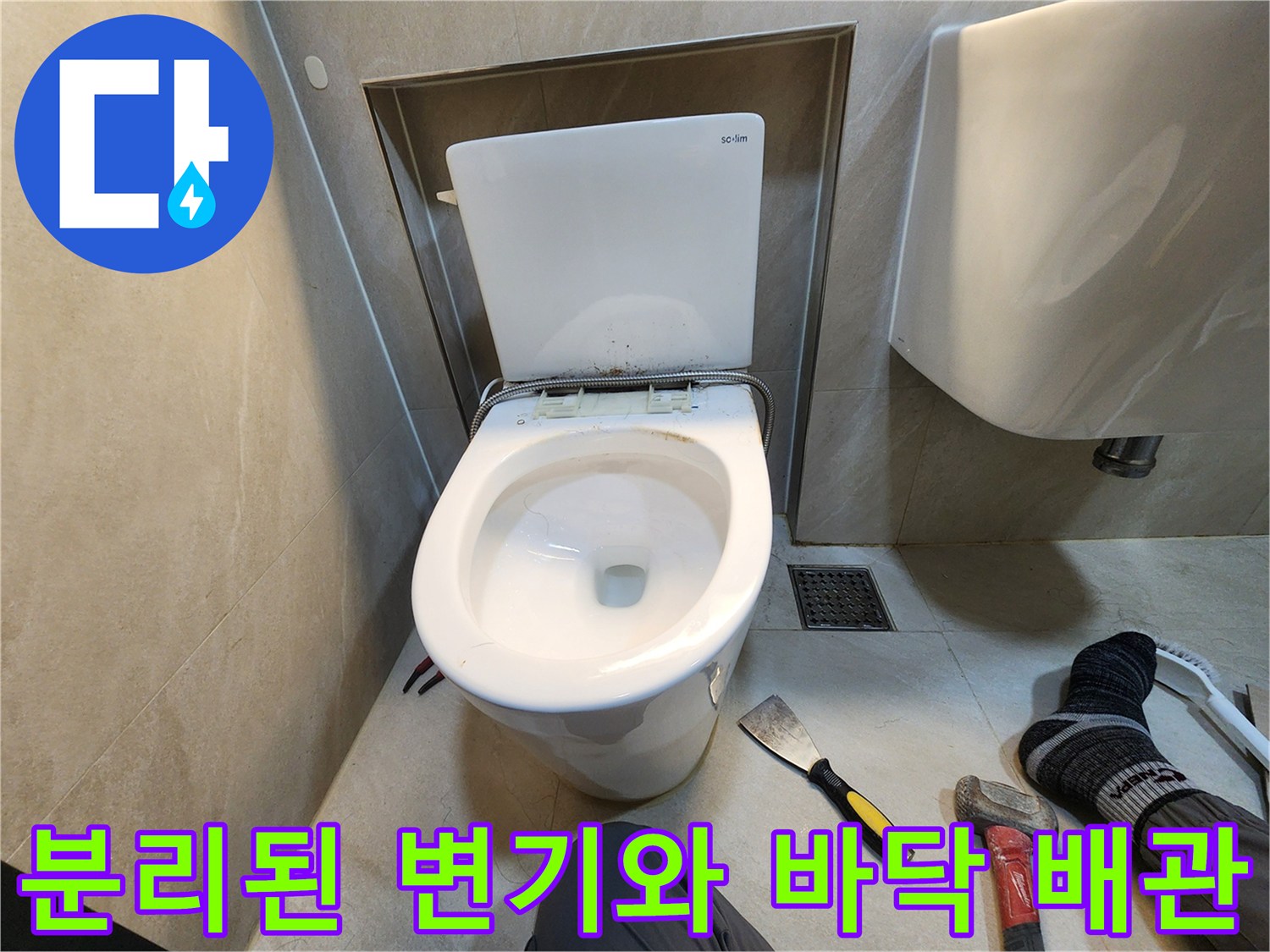 변기를 분리한 후 드러난 배관 주변의 오염된 타일 상태입니다.