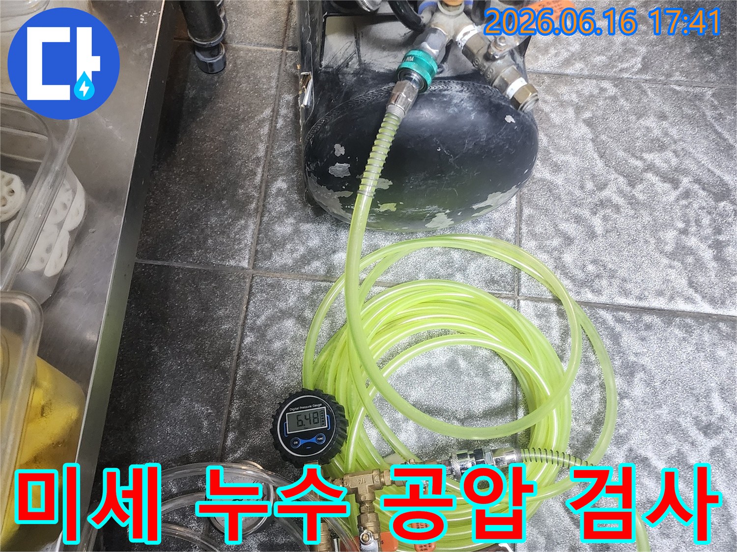 이 사진은 미세한 누수까지도 놓치지 않고 찾아내기 위해-공압 검사 장비를 사용하여-배관의 압력을 정밀하게 측정하는 모습입니다