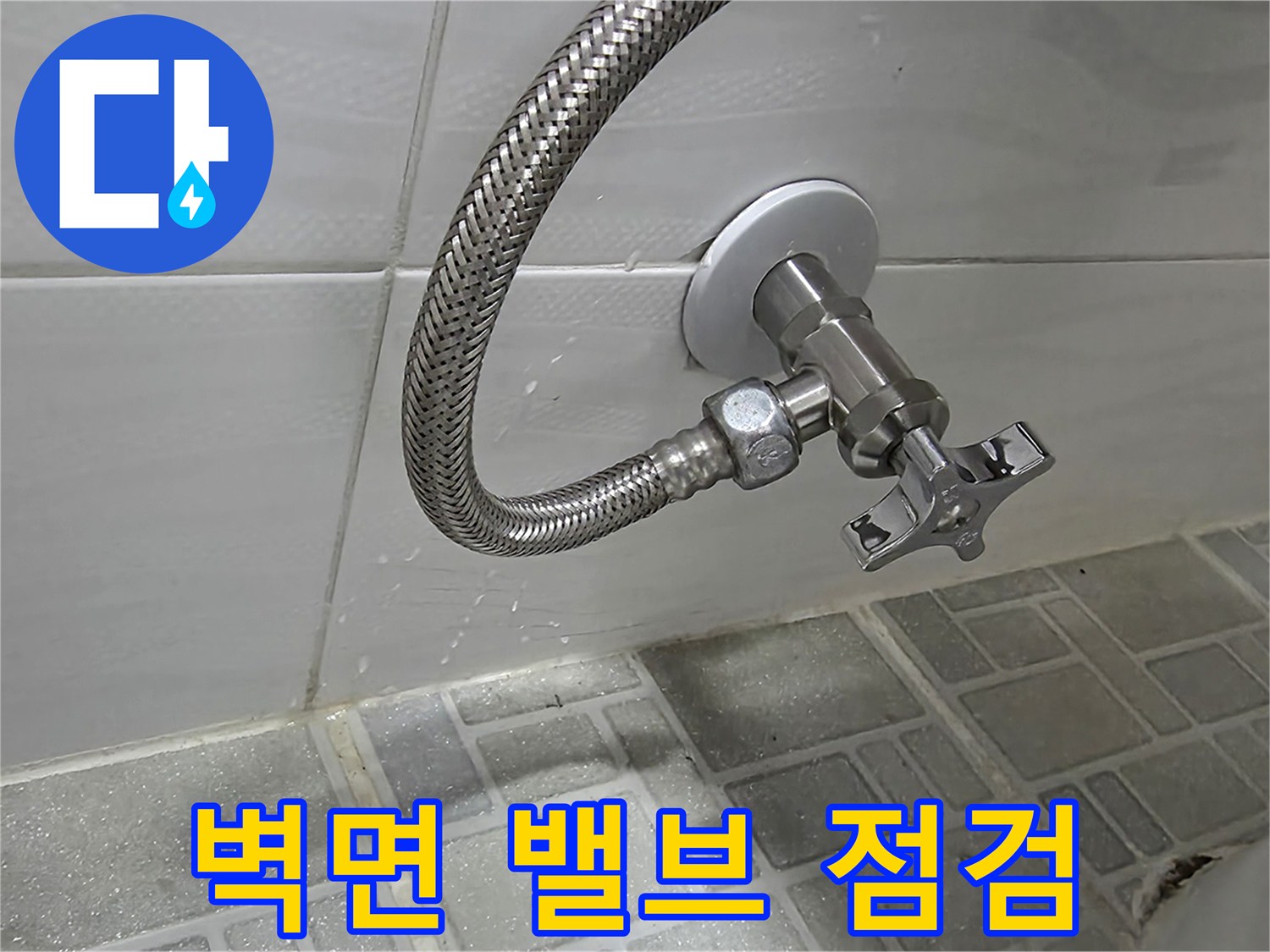 벽면에 설치된 은색 수도 밸브와 샤워 호스-연결 부위 근접 촬영