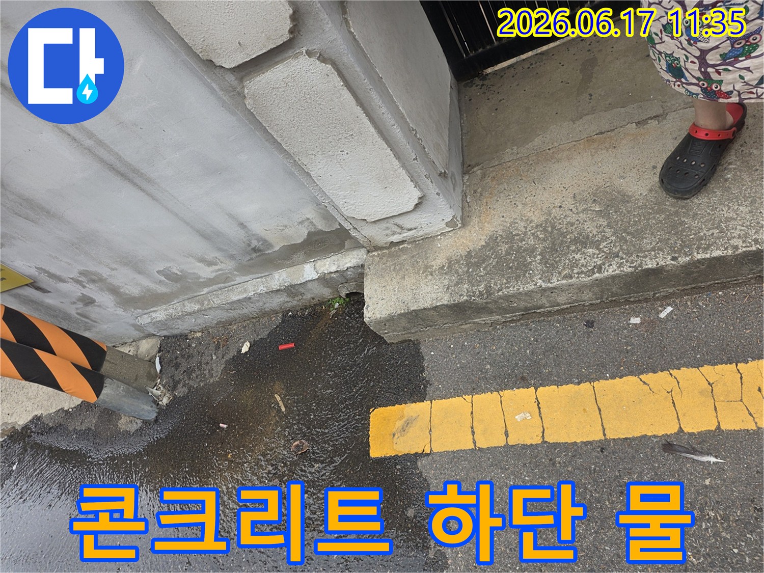 콘크리트-기초-아래에서-새어-나온-물이-도로-아스팔트-위에-고여있는-모습