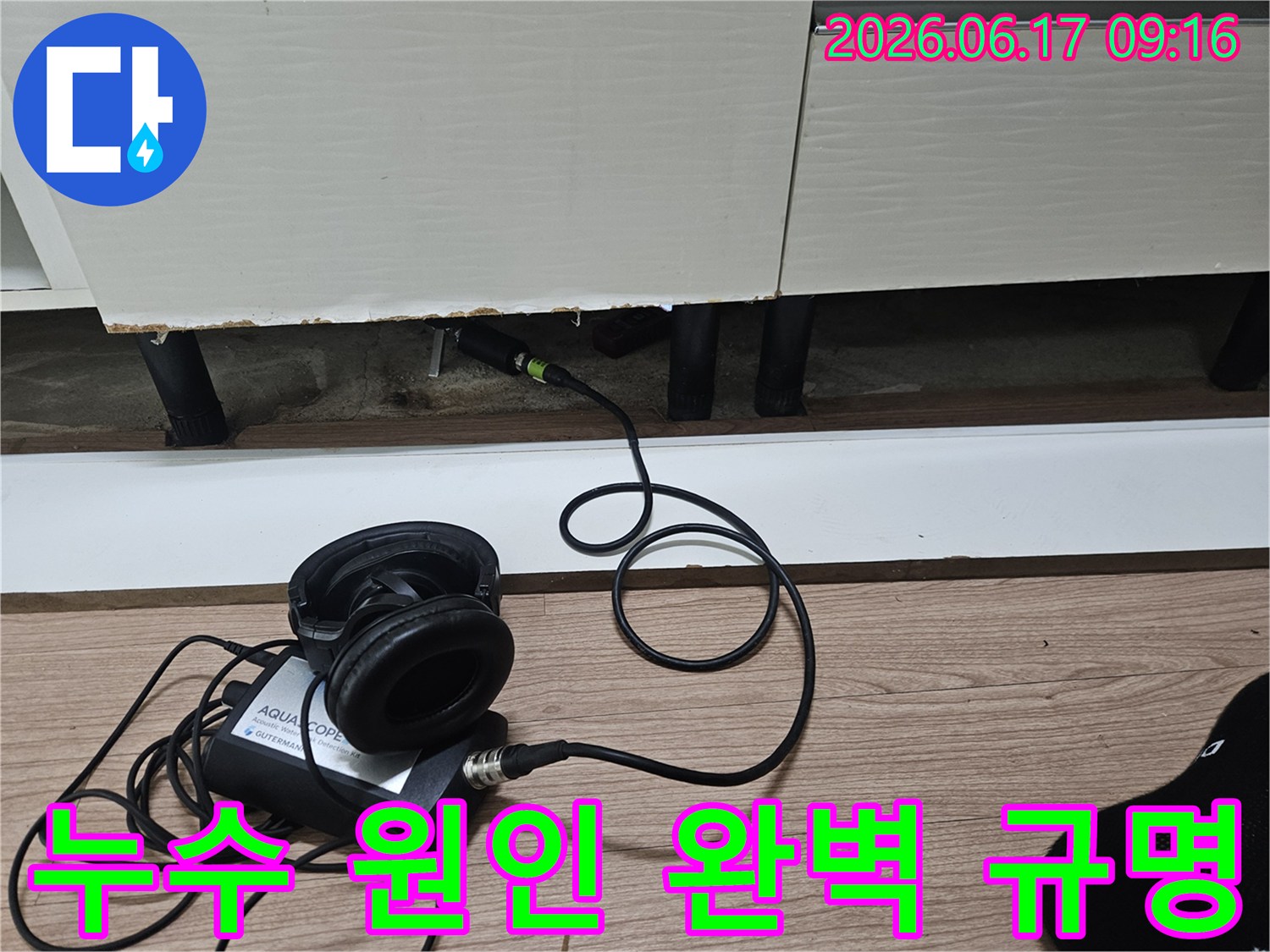 누수 탐지 엔지니어가-첨단 청음식 장비를 사용하여-싱크대 하부의 누수 원인을 규명하는 모습
