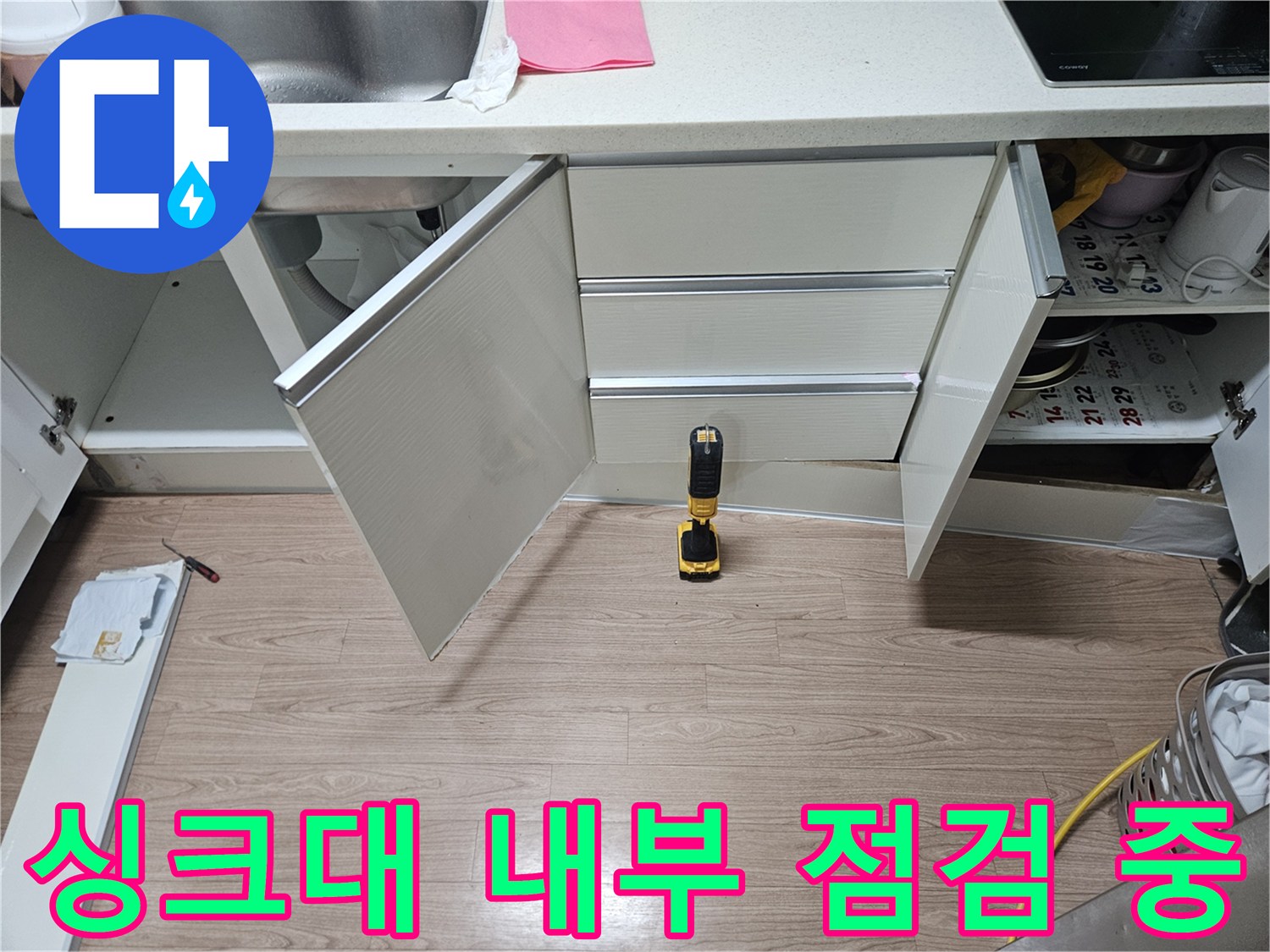 비어있는 싱크대 하단 수납장과 작업 도구 - 배관 누수 탐색 준비