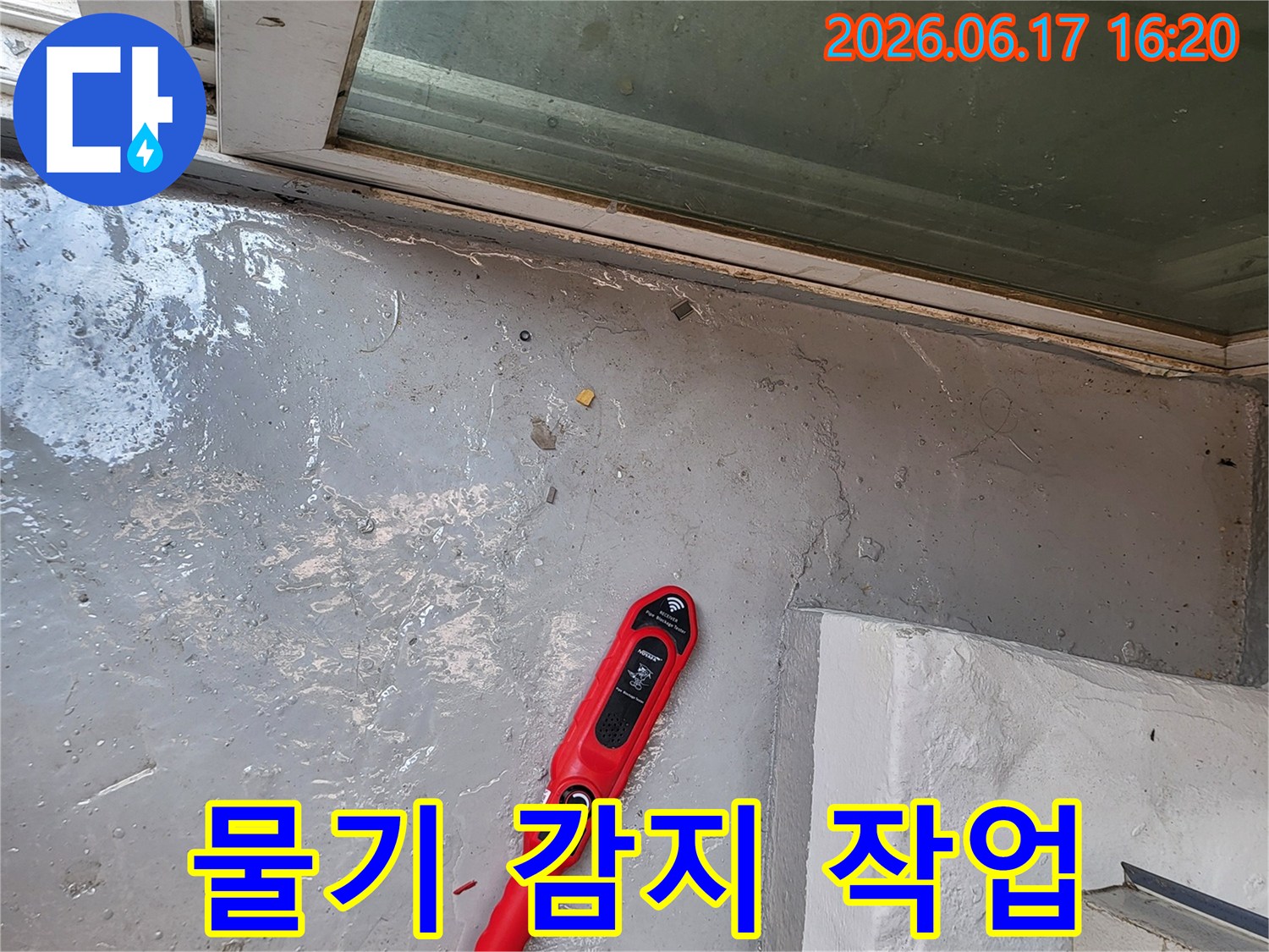 누수-전문가가-베란다-바닥의-물기-위에서-누수-탐지기를-사용하여-정확한-누수-지점을-찾아내는-장면