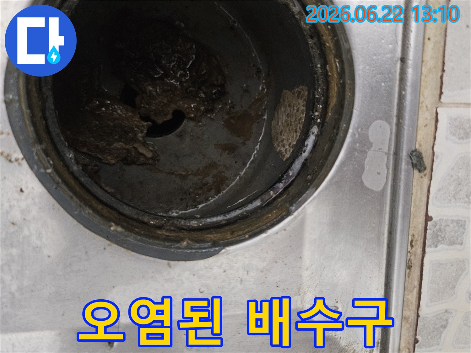 더러워진 스테인리스 배수구 내부와-검은색 이물질이 가득한 모습은-전문적인 배관 청소의 필요성을 강조합니다.