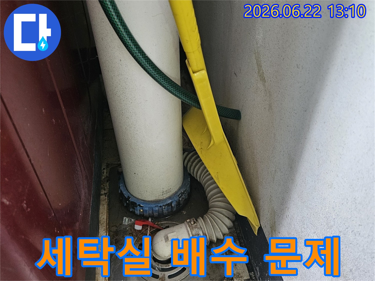 세탁실 배수관과-하수구 연결 부위에서-누수 여부를 확인하는-장면입니다.