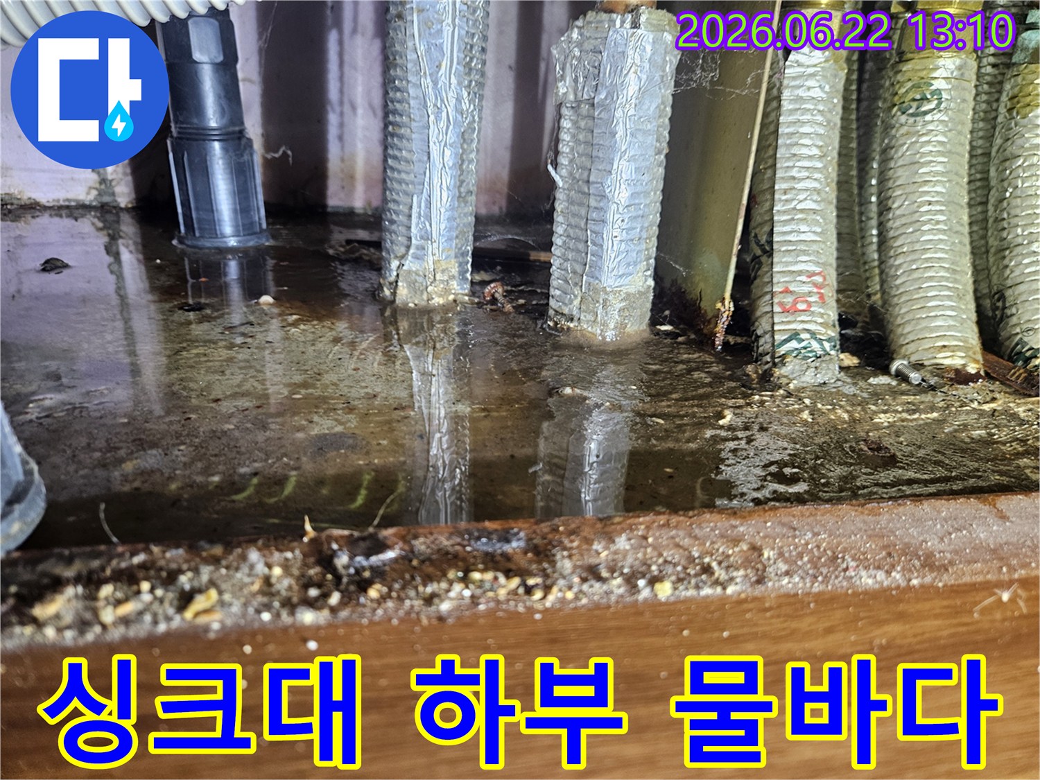 싱크대 아래 공간에 물이 가득 고여-배관이 침수된 심각한 누수 현장입니다.