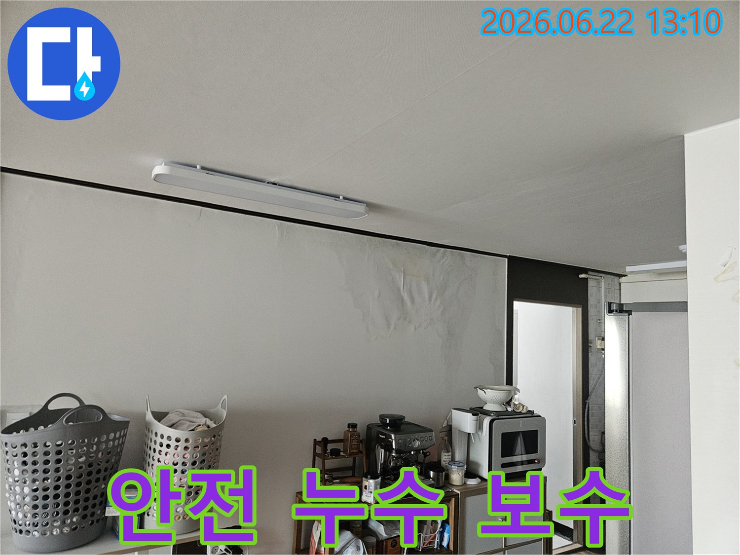 이 이미지는 천장 누수로 인해 벽면이 심하게 젖어-벽지가 들뜨고 곰팡이가 생기기 시작한 아파트 내부의 모습을 보여줍니다.
