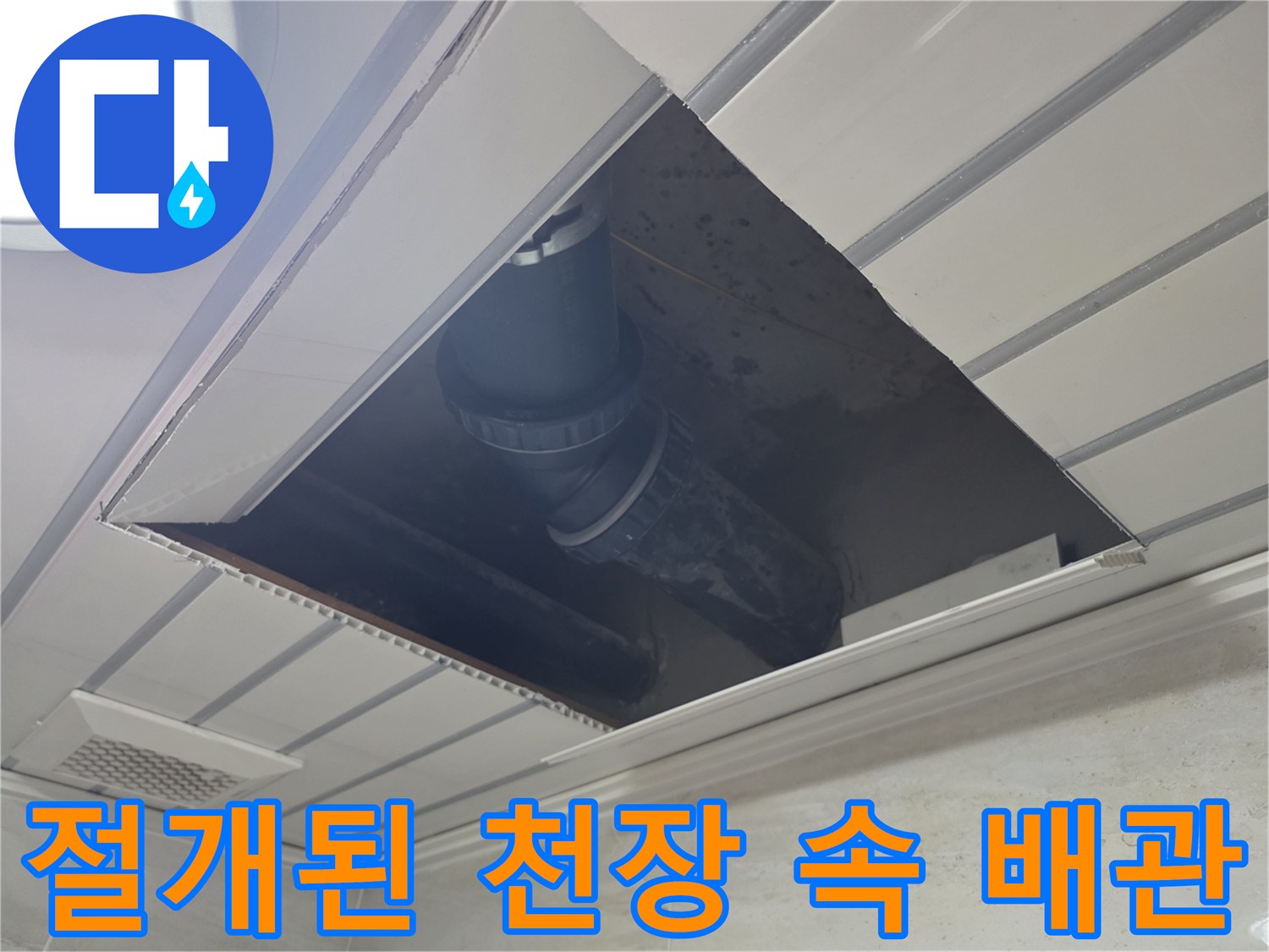 천장 마감재 사이로 노출된 굵은 배관과 주변 환경
