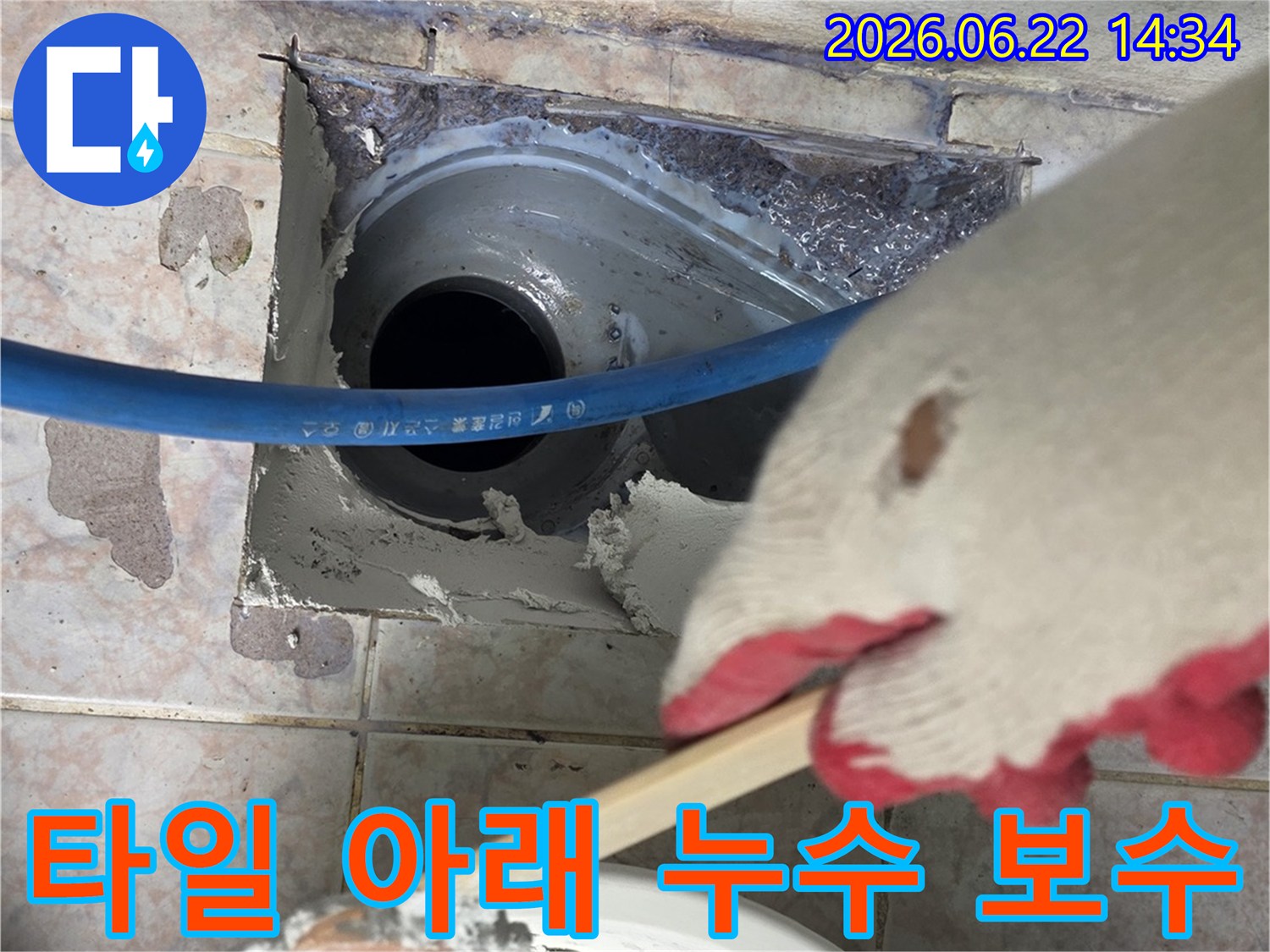 작업자가-누수-지점의-타일을-제거하고-배관-주변을-몰탈로-보강하는-장면