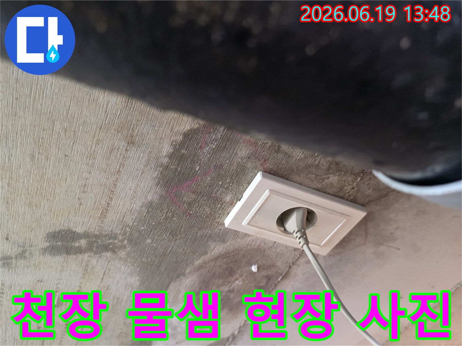 천장에서 물이 새어 콘센트 주변에 얼룩이 생긴 모습으로-누수 발생 현장을 명확히 보여주는 이미지입니다