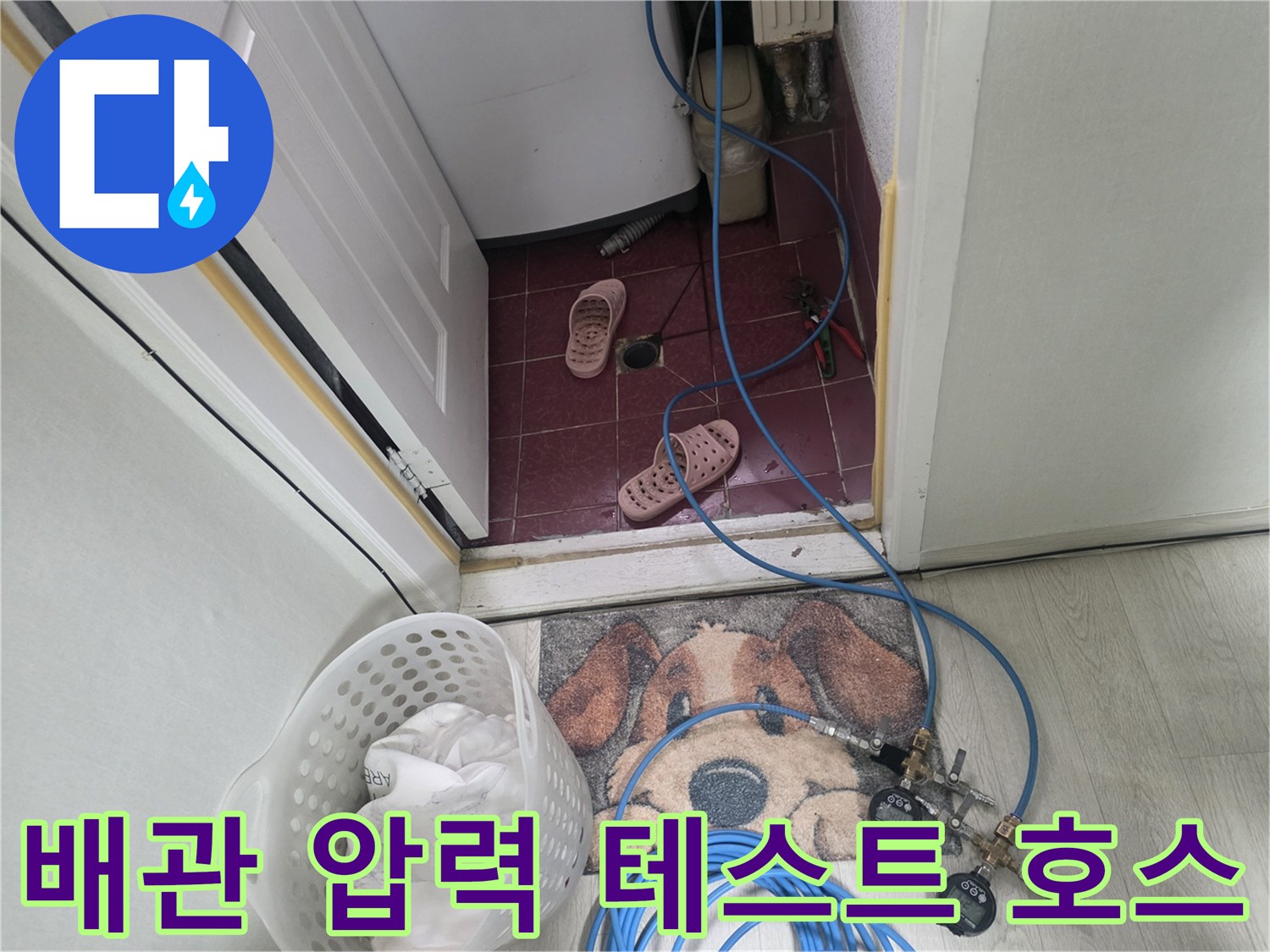 바닥 타일 위로 길게 연결된 파란색 공압 검사용 호스와 밸브 장치