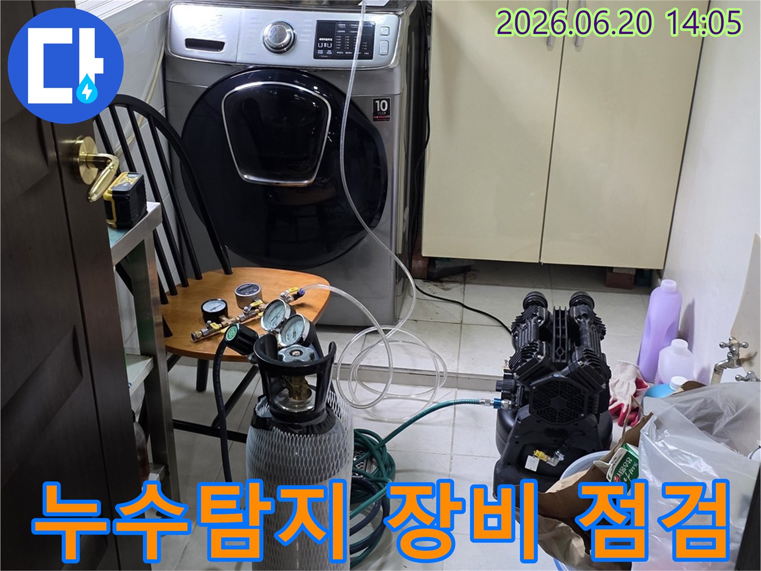 세탁실 배관 누수 확인을 위해-전문 탐지 장비를 점검하고-압력 검사를 진행하는 모습