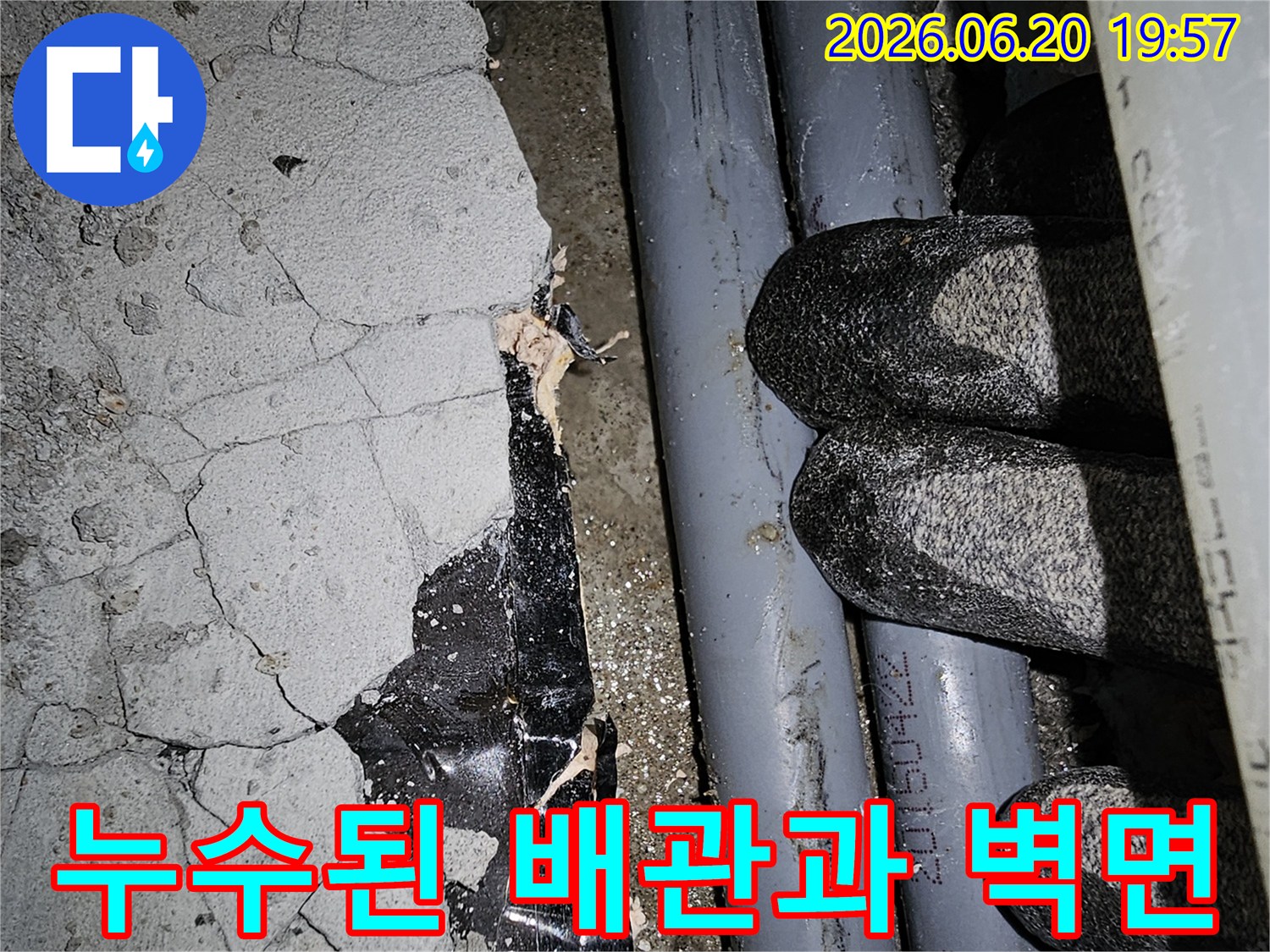 균열이 발생한 콘크리트 벽면과-노출된 배관 주변의-누수 현장을 보여줍니다