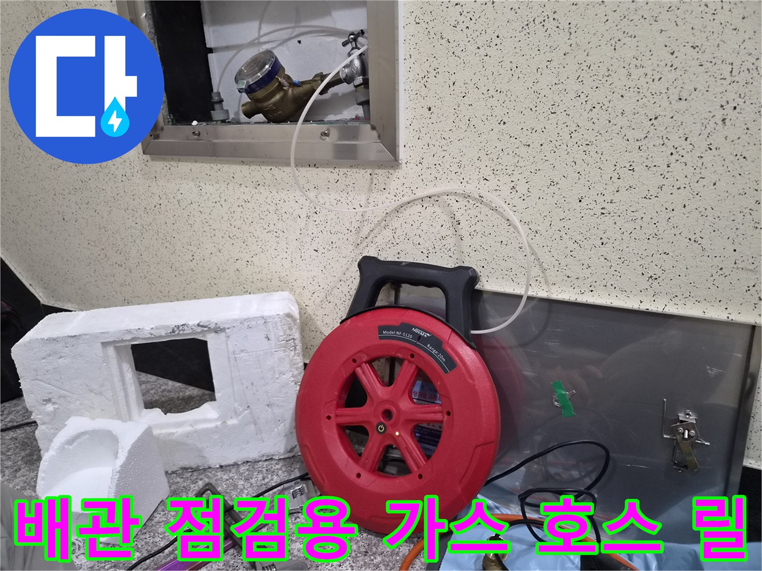 현장에서 사용 중인 붉은색 가스 탐지 호스 릴과 벽면 배관 구조물