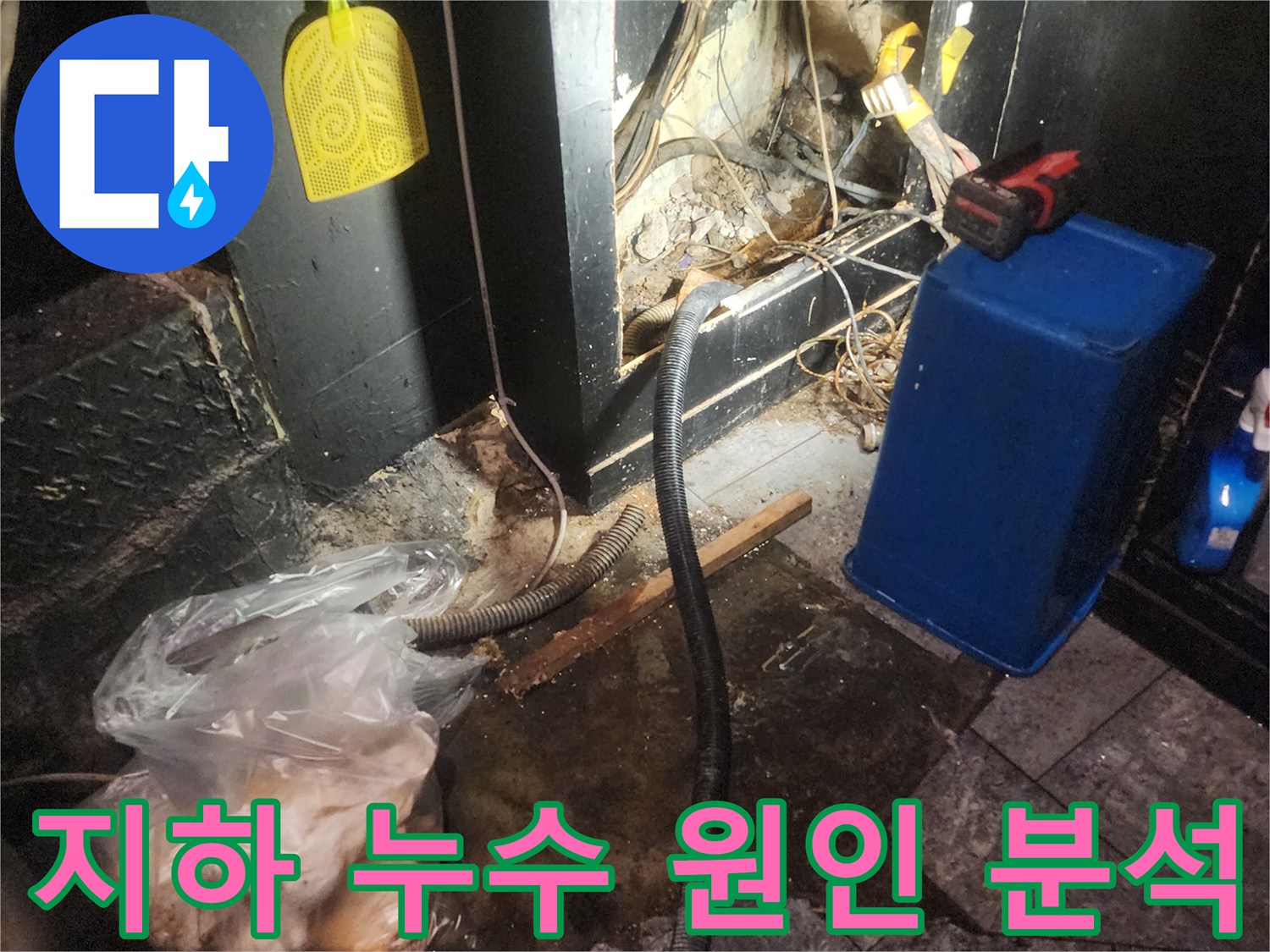 어둡고 습한 지하 공간에서 복잡한 배관과 전선-그리고 물이 고여있는 바닥을 보여주며 누수 원인을 분석하는 현장 사진
