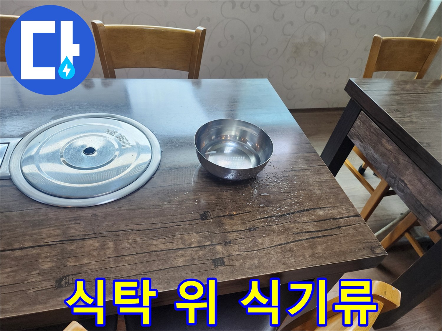 나무 식탁 위에 놓인 스테인리스 냄비와 그릇