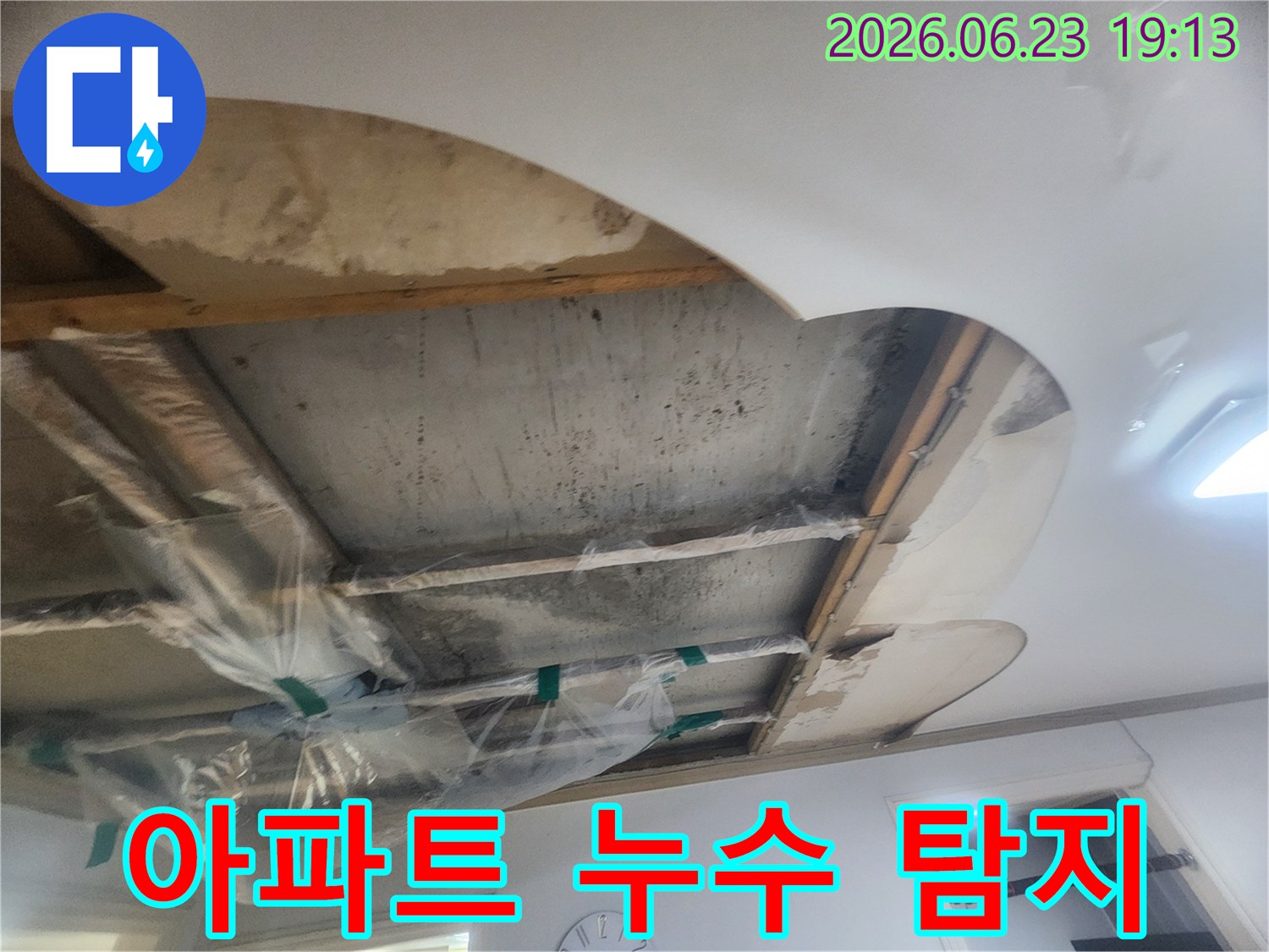 윗집 누수로 인해-콘크리트 슬라브가 젖어있고-배관 주변에 비닐 보양을 한 상태를 보여줍니다