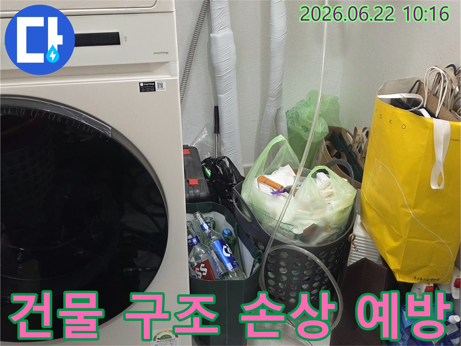 세탁실-벽면에-설치된-배관의-누수-여부를-정밀하게-점검하여-장기적인-건물-구조-손상을-예방하는-전문가의-모습
