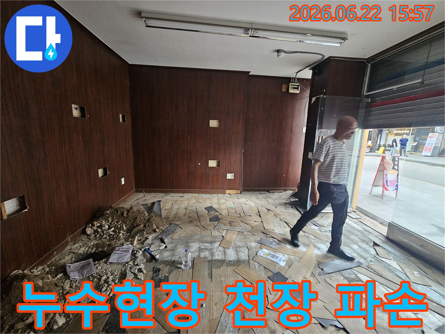 누수로 인해-천장 마감재가-크게 파손되고-내부 구조물이-노출된 상가-내부 현장입니다-전문 엔지니어가-피해 상황을-정밀하게-조사하고 있습니다.