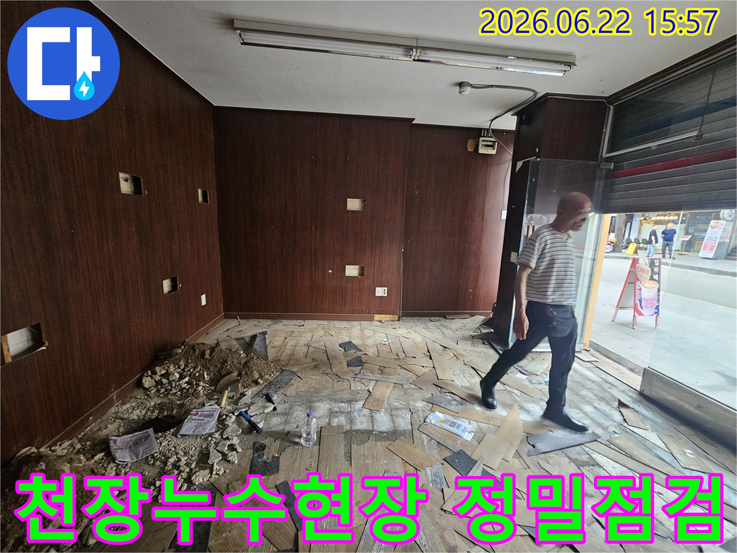 이 이미지는-천장 누수로 인해-내부 마감재가 손상된-상가 건물 내부를-보여주고 있습니다-누수 엔지니어가-현장을 면밀히-살피는 모습입니다.