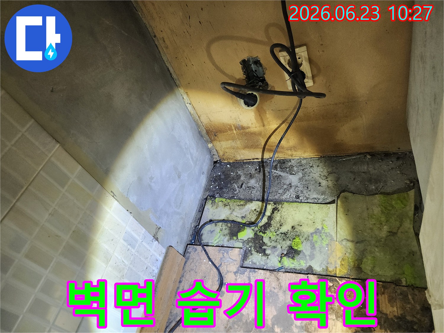 바닥재-손상과-벽면-습기-그리고-전기-콘센트-주변의-위험한-상황을-보여주는-누수-현장-사진입니다.
